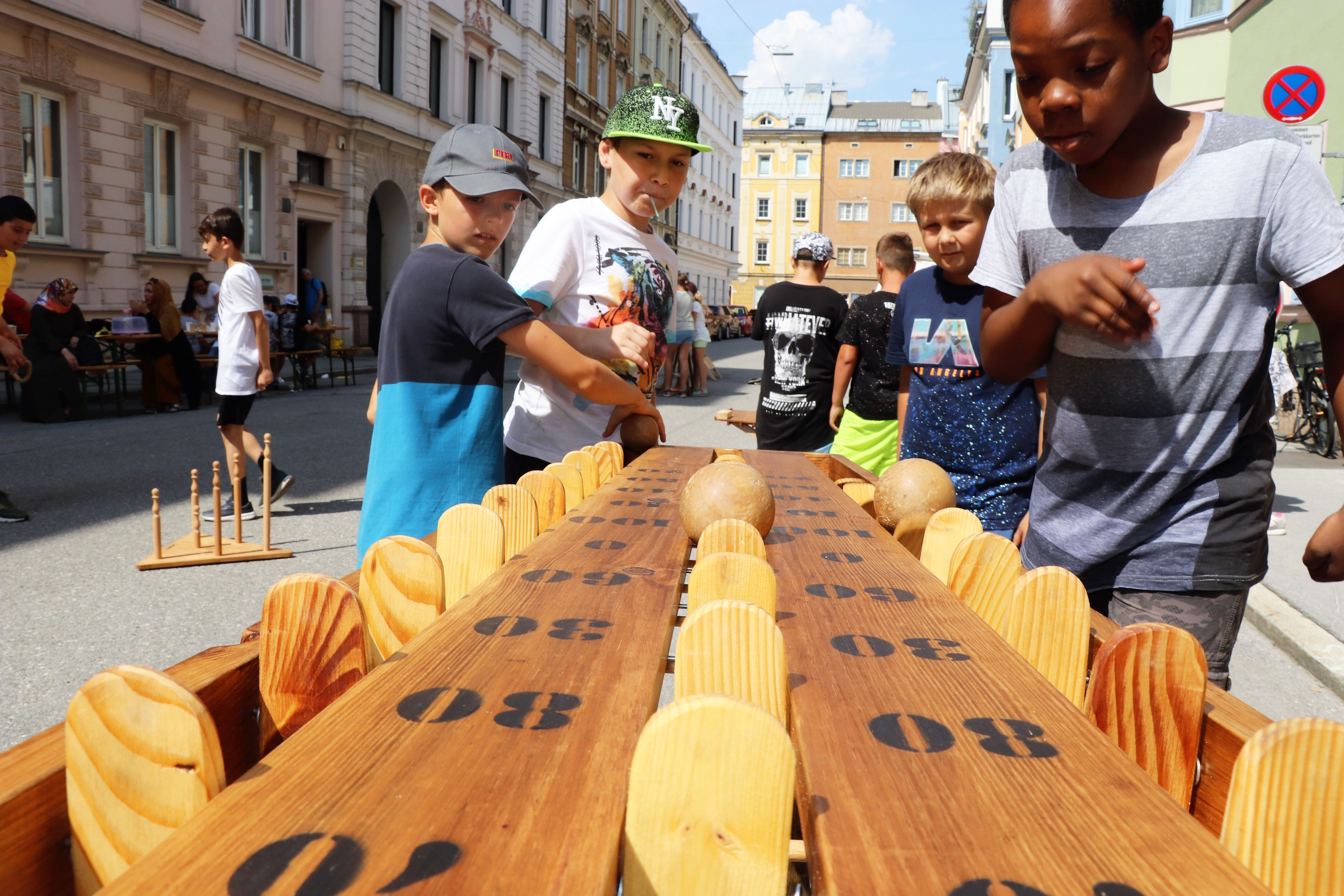 Am 1. Juli begrüßten die SchülerInnen der Volksschule Franz-Fischer-Straße Bürgermeister Georg Willi bei ihrem Sommerfest mit Spielen aus alter Zeit. Nicht nur die Kinder, auch der Bürgermeister waren trotz Hitze mit Feuereifer bei der Sache.