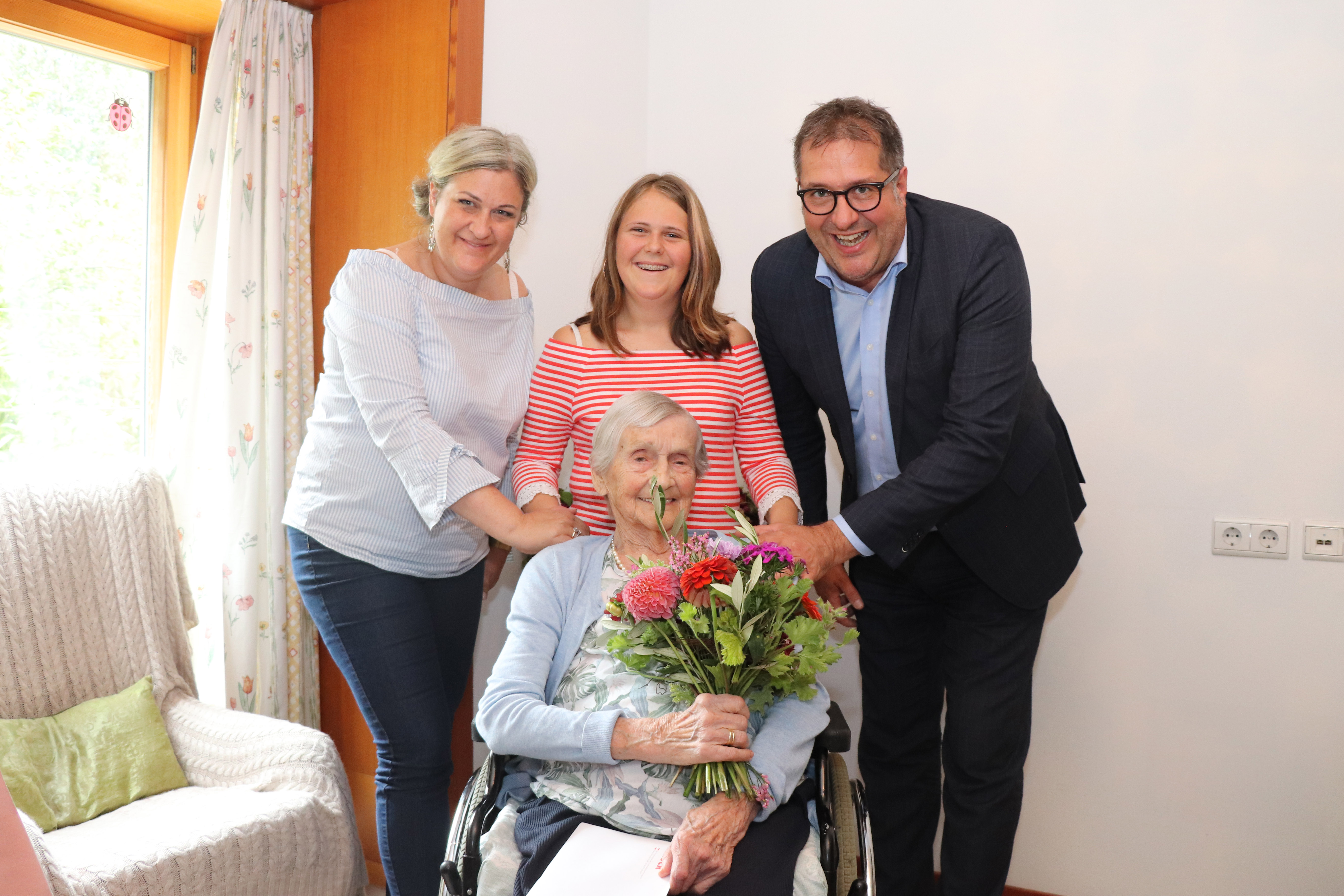 Vizebürgermeister Franz X. Gruber überbrachte die besten Wünsche an Jubilarin Gertrud Wlachowsky und überreichte im Beisein von Enkelin Simone (l.) und Urenkelin Marie (M.) einen Strauß bunter Blumen.