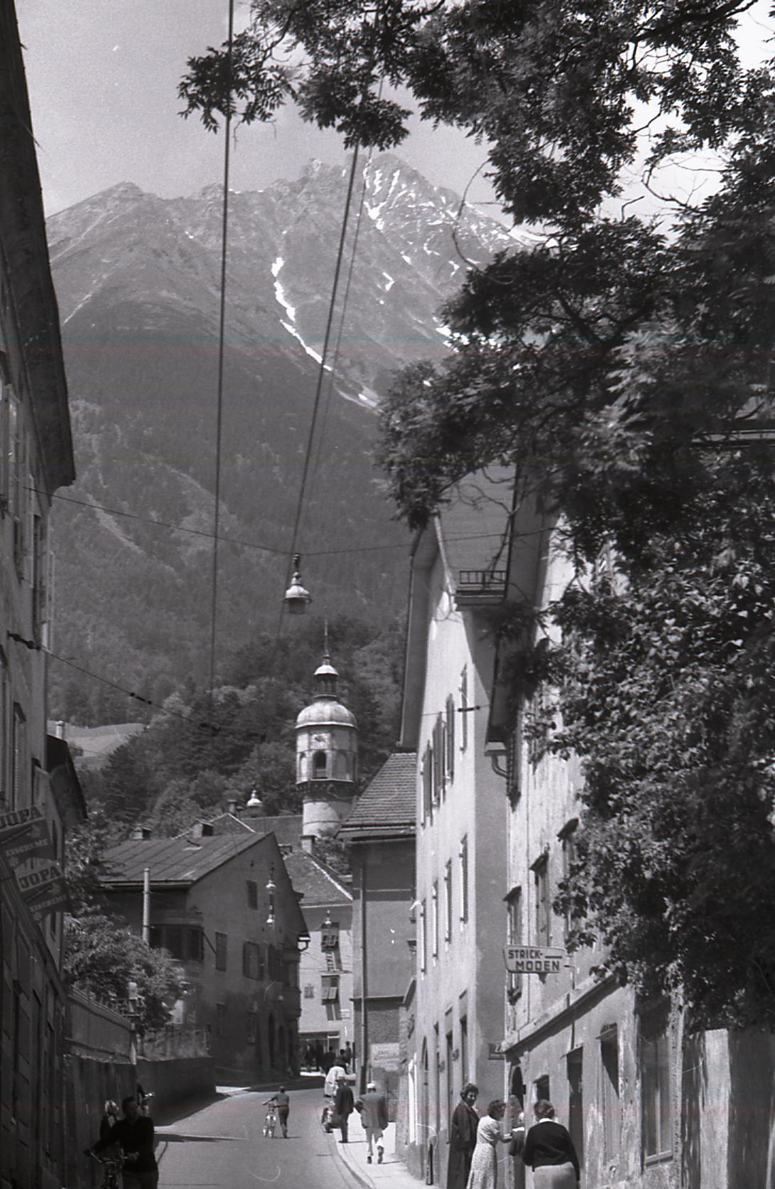 Hötting: Ein Mann schiebt sein Fahrrad auf der Straße. Foto vom 18. Juni 1963