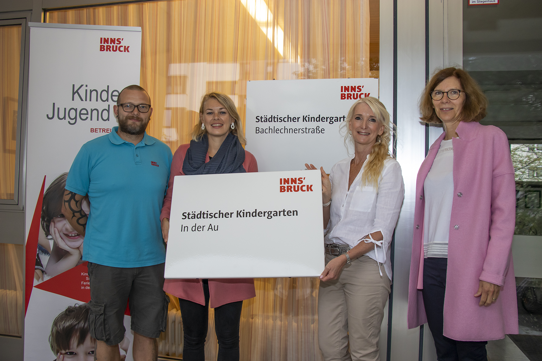 Das neue Namensschild ziert jetzt das Gebäude des Kindergartens im Stadtteil Höttinger Au. Stadträtin Elisabeth Mayr (2. v. l.), Amtsvorständin Martina Zabernig (Kinder, Generationen und Jugend, r.), Kindergartenleiterin Birgit Warger (2. v. r.) und Schulwart Richard Mathoi zeigten sich über die Maßnahme erfreut.