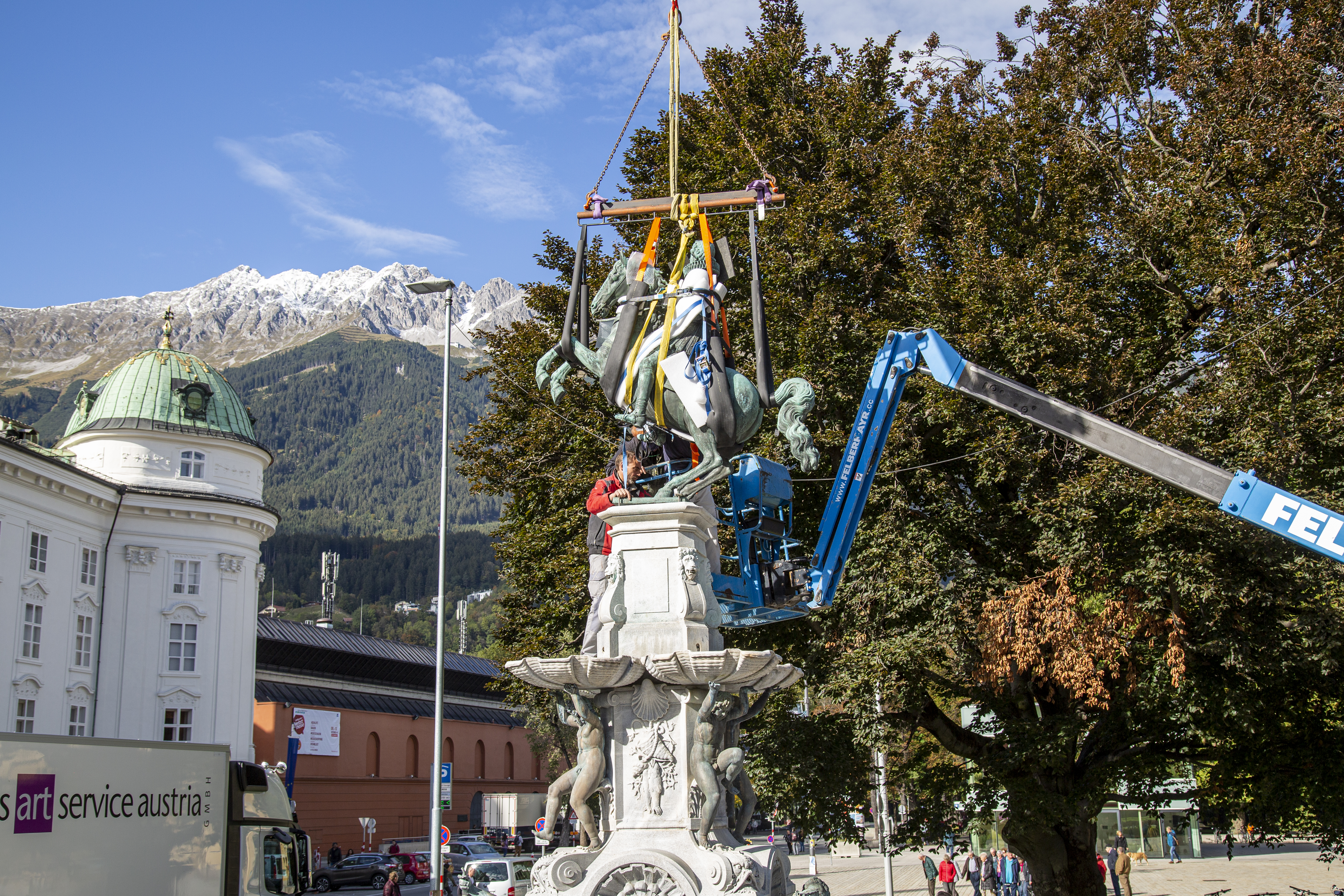 In millimetergenauer Arbeit wird das Erzherzog-Leopold-Reiterstandbild auf die Befestigung am Brunnensockel gehoben.