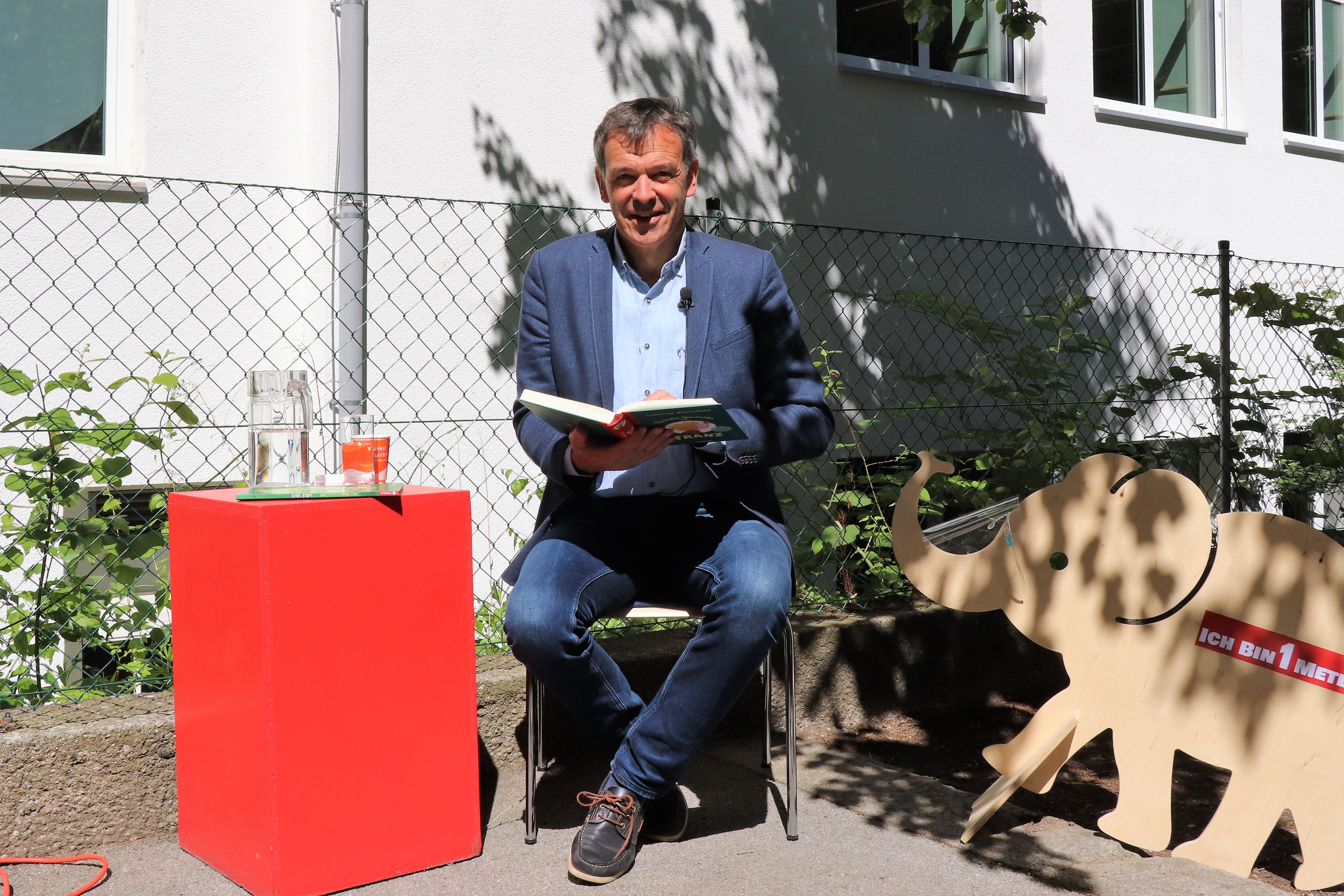 Auch in Zeiten von Corona war die Vorlesestunde mit Bürgermeister Georg Willi in der Volksschule Franz-Fischer-Straße ein großer Erfolg. Die SchülerInnen lachten über Christine Nöstlingers "Geschichten vom Franz" und lernten ganz zeitgemäß mit "Willi Virus" von Heidi Trpak, wie man sich vor Ansteckung schützt. 
Die Vorlesestunde fand im Freien und mit dem erforderlichen Abstand zwischen den Kindern statt. Dafür hatte der Schulleiter Direktor Martin Müller vorbildlich gesorgt: Unter anderem erinnerte auch ein Babyelefant an das notwendige Abstandhalten. Das tat der spürbaren gemeinsamen Freude am Vorlesen und Zuhören aber keinen Abbruch.