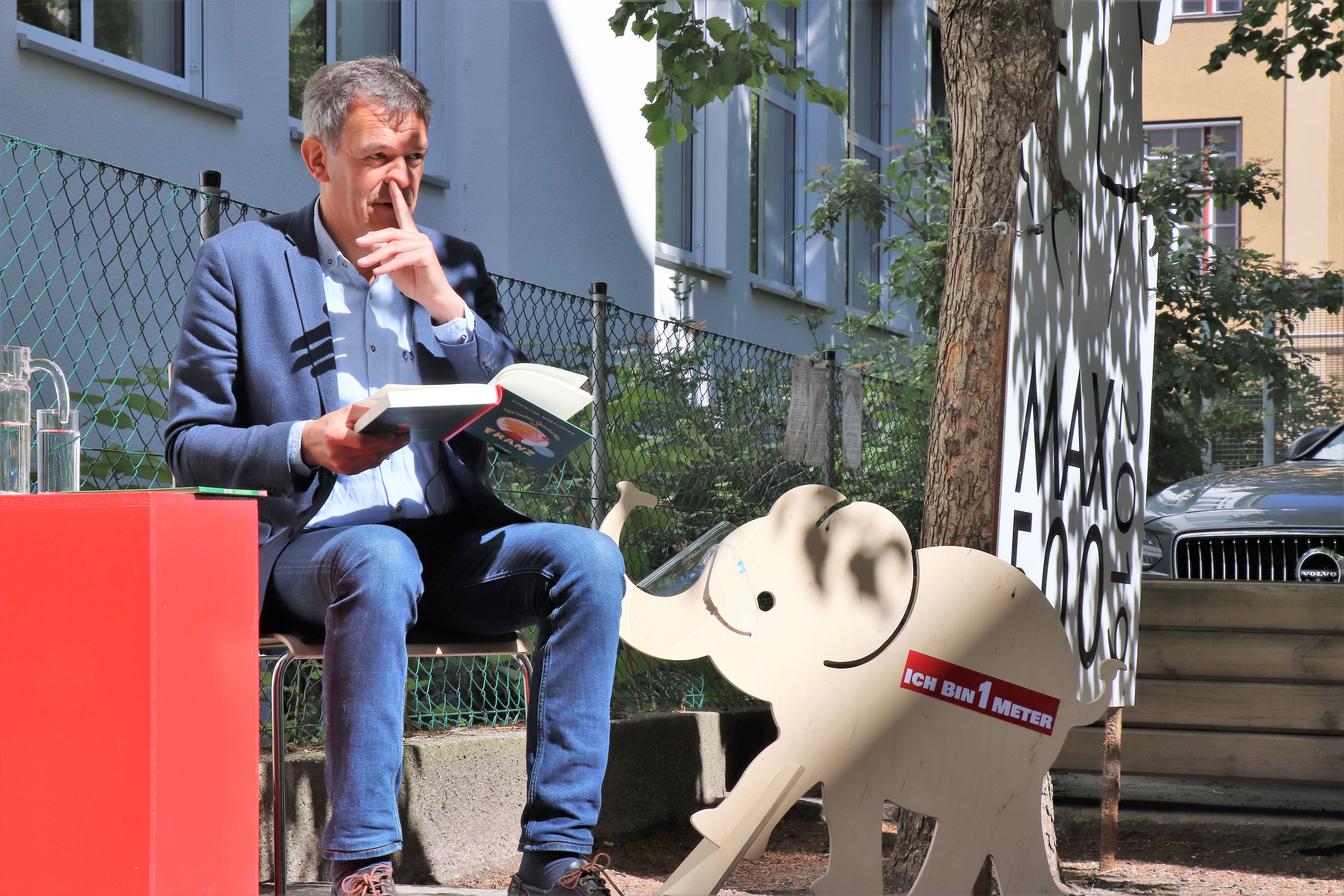 Auch in Zeiten von Corona war die Vorlesestunde mit Bürgermeister Georg Willi in der Volksschule Franz-Fischer-Straße ein großer Erfolg. Die SchülerInnen lachten über Christine Nöstlingers "Geschichten vom Franz" und lernten ganz zeitgemäß mit "Willi Virus" von Heidi Trpak, wie man sich vor Ansteckung schützt. 
Die Vorlesestunde fand im Freien und mit dem erforderlichen Abstand zwischen den Kindern statt. Dafür hatte der Schulleiter Direktor Martin Müller vorbildlich gesorgt: Unter anderem erinnerte auch ein Babyelefant an das notwendige Abstandhalten. Das tat der spürbaren gemeinsamen Freude am Vorlesen und Zuhören aber keinen Abbruch.