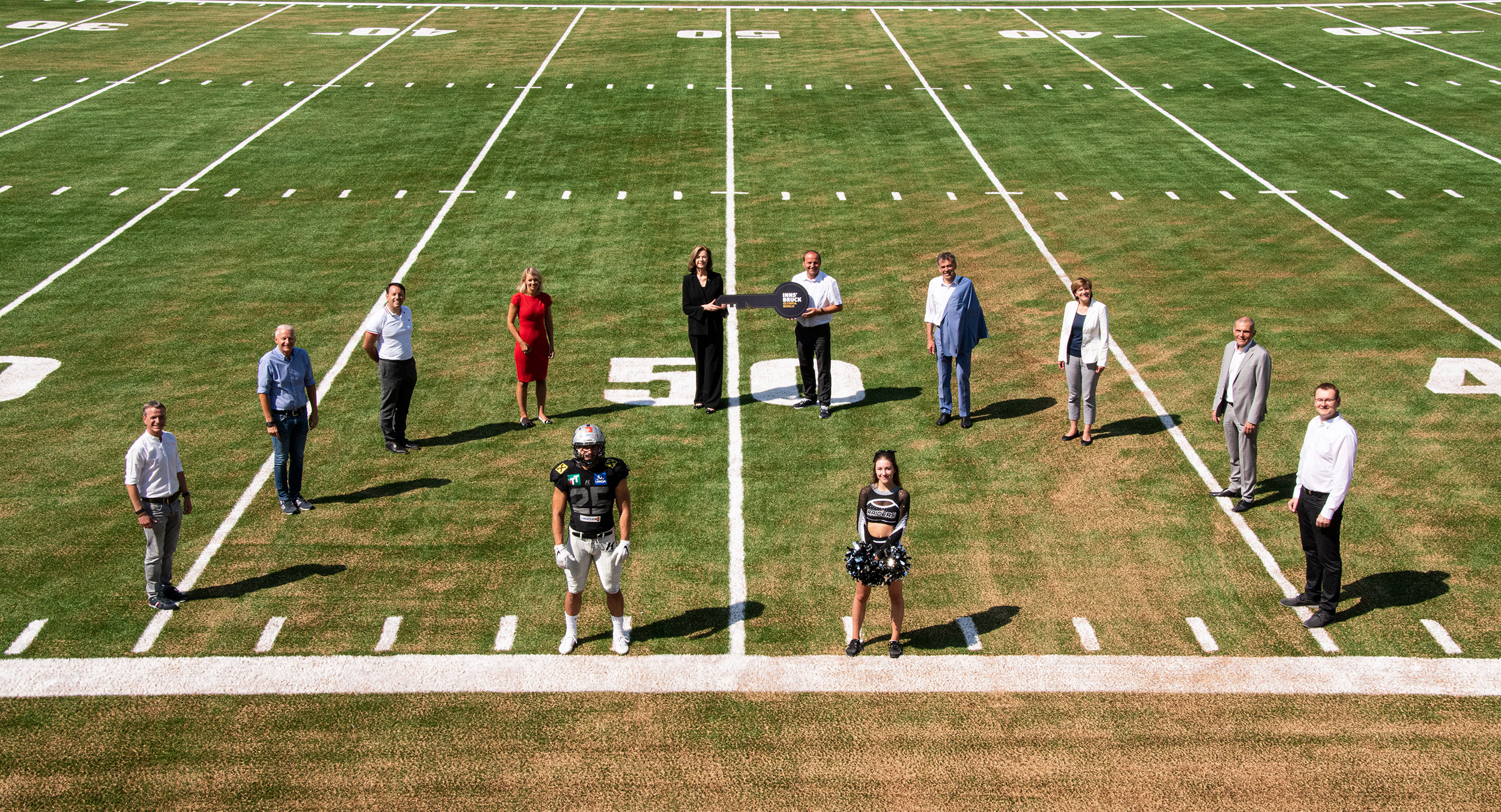 Bei der Schlüsselübergabe für das neue Football-Zentrum: OSVI-Prokurist Christoph Kaufmann, OSVI-GF Matthias Schipflinger, IIG-GF Franz Danler, StRin Elisabeth Mayr, Raiders-Präsidentin Elisabeth Swarovski, LHStv. Josef Geisler, BM Georg Willi, StRin Christine Oppitz-Plörer, Vorsitzender Christian Girardi (OSVI-Aufsichtsrat) und AFCVT-Präsident Gerwin Wichmann (v.l.) gemeinsam mit Raiders-Spieler Tobias Bonatti und Cheerleaderin Lea Deutsch.