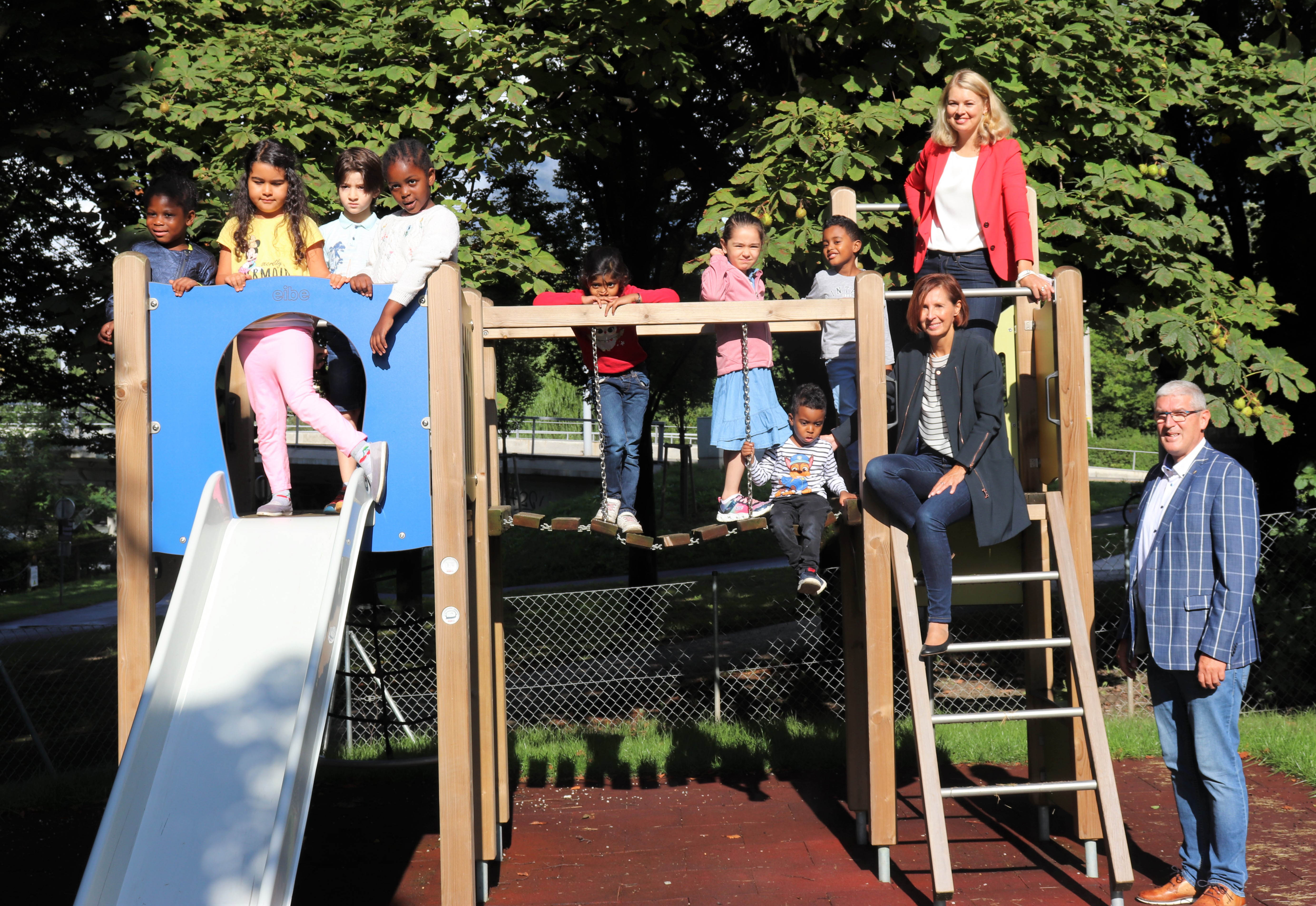 Über den Startschuss des Projekts „Deutsch im Sommer“ im Kindergarten Schützenstraße freuten sich Landesrätin Gabriele Fischer (Klettergerüst unten), Stadträtin Elisabeth Mayr (Klettergerüst oben) und der stellvertretende Landesleiter des Tiroler Jugendrotkreuz Wolfgang Haslwanter (r.) gemeinsam mit den Kindern des Kindergarten Schützenstraße.