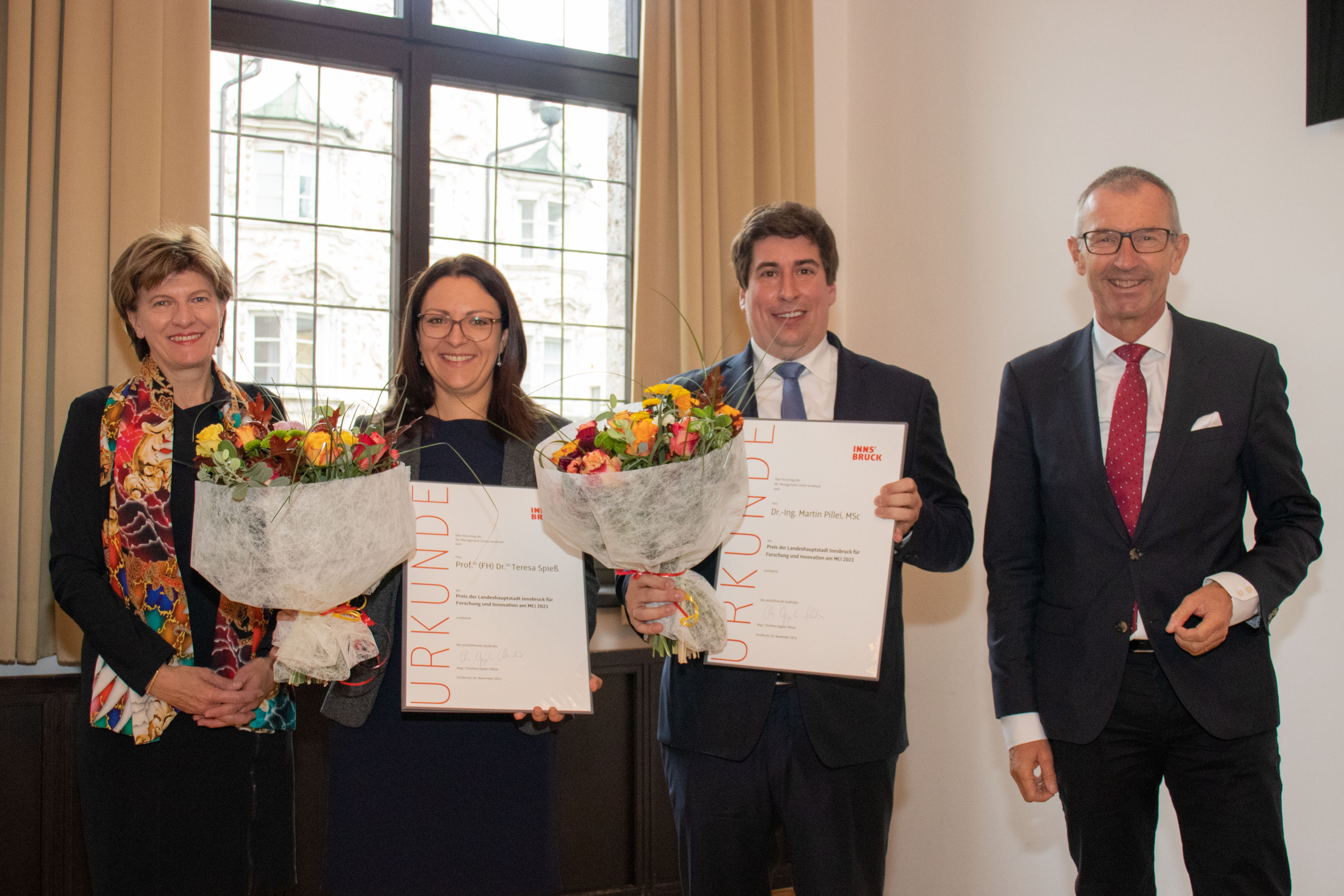 Stadträtin Christine Oppitz Plörer (l.) und Rektor des MCI, Andreas Altmann, gratulierten Preisträgerin Teresa Spieß und Martin Pillei zum Preis der Landeshauptstadt Innsbruck für Forschung und Innovation am Management Center Innsbruck (MCI) 2021.