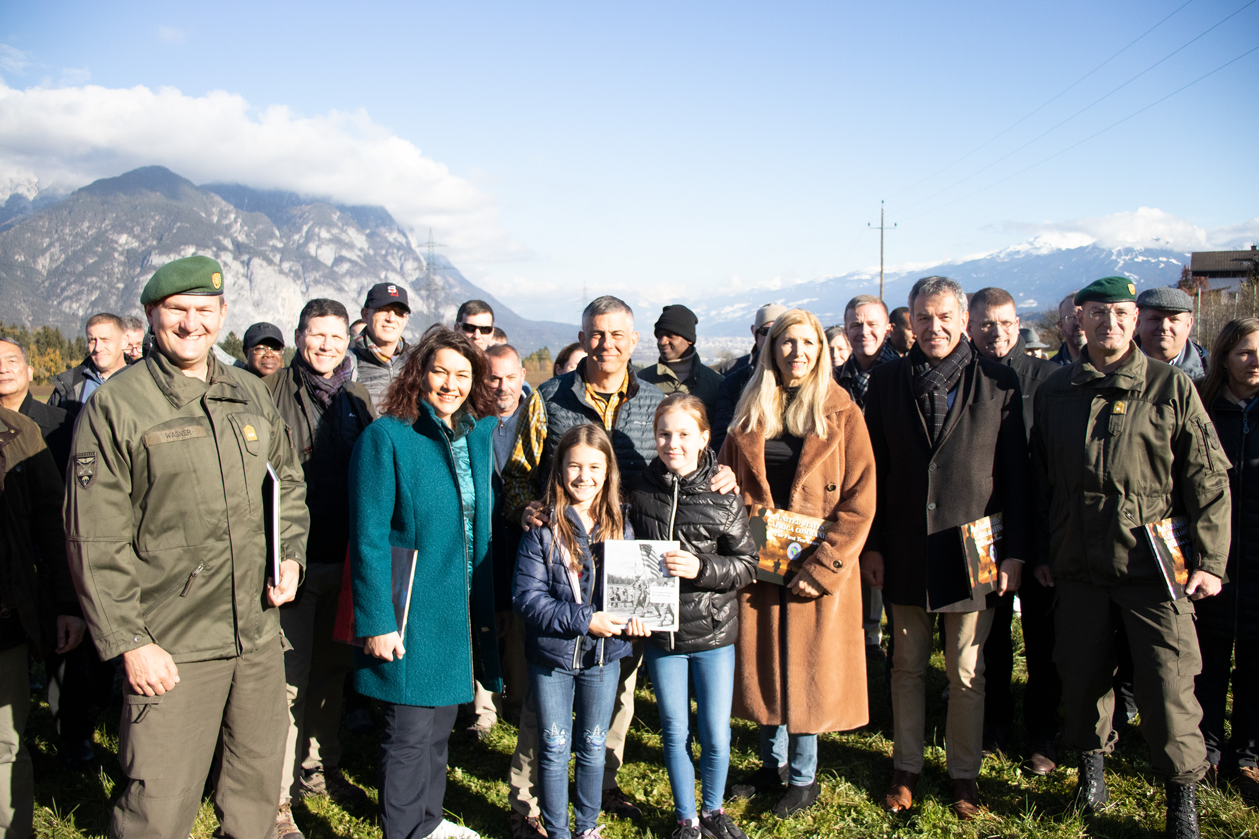 Ganz im Zeichen der im Frühjahr 1945 durchgeführten Befreiungsmission „Operation Greenup“ stand ein Treffen mit Angehörigen der US-Army in Oberperfuss. Landeshauptmann-Stellvertreterin Ingrid Felipe (2.v.r.), der Innsbrucker Bürgermeister Georg Willi, Tirols Militärkommandant Ingo Gstrein (rechts) und die Oberperfer Bürgermeisterin Johanna Obojes-Rubatscher begrüßten General Stephen J. Townsend (2.v.l.), der das Africa Command der US-Streitkräfte (Africom) mit Hauptsitz in Stuttgart anführt. Rund 60 SoldatInnen besuchten in einer eintägigen Exkursion Oberperfuss, um mehr über die spektakuläre Spionagemission der beiden US-Agenten Fred Mayer und Hans Wijnberg zu erfahren, die zusammen mit dem Tiroler Wehrmachtsdeserteur Franz Weber entscheidend zur Befreiung Innsbrucks im Mai 1945 beitrugen (nächstes Bild!).

Im Februar 1945 landeten die drei Agenten Fred Mayer, Hans Wijnberg und der aus der deutschen Wehrmacht desertierte Franz Weber per Fallschirm in Tirol. Von Oberperfuss aus fingen sie Nachrichten ab und übermittelten diese an die in Italien stationierten US-Truppen. Im April gelang ihnen schließlich mit Unterstützung von Webers in Innsbruck lebenden Schwestern, seiner Verlobten Anni und der lokalen Bevölkerung in Oberperfuss, den Tiroler Gauleiter Franz Hofer von der widerstandslosen Kapitulation zu überzeugen und ihn sowie weitere führende NS-Kräfte festzunehmen. Im Bild (v.l.) Franz Weber, Fred Mayer und (vorne) Hans Wijnberg wenige Tage nach der Befreiung im Mai 1945 (nächstes Bild!).

Während in den USA die Geschichte von der erfolgreichen Spionage durch die Presse ging, wurde sie in Tirol beinahe vergessen. Bis der Historiker Peter Pirker sie penibel recherchierte und im Buch „Codename Brooklyn“ 2018 veröffentlichte. Beim Besuch in Oberperfuss besuchten die Mitglieder des Africom auf Einladung des Gemeindemuseums Absam die Schauplätze des damaligen Einsatzes. Von der Tiroler Delegation gab es als Geschenk das Buch „Schnappschüsse der Befreiung“ von Peter Pirker und Mathias Breit. Die Africom ist eine besonders gut ausgebildete Eingreiftruppe der US-Army, die im Schnitt aus rund 6.000 Militärangehörigen besteht. Der Besuch in Tirol diente der Erforschung der erfolgreichen Mission am Ende des zweiten Weltkrieges.