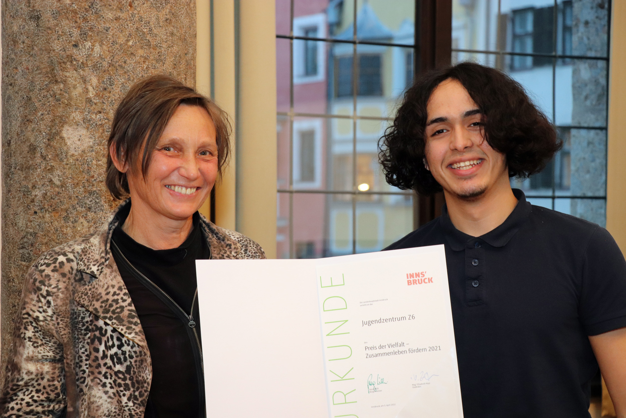 Stolz präsentiert Elfi Oblasser gemeinsam mit einem Jugendlichen des Z6 die Urkunde zum Preis der Vielfalt.