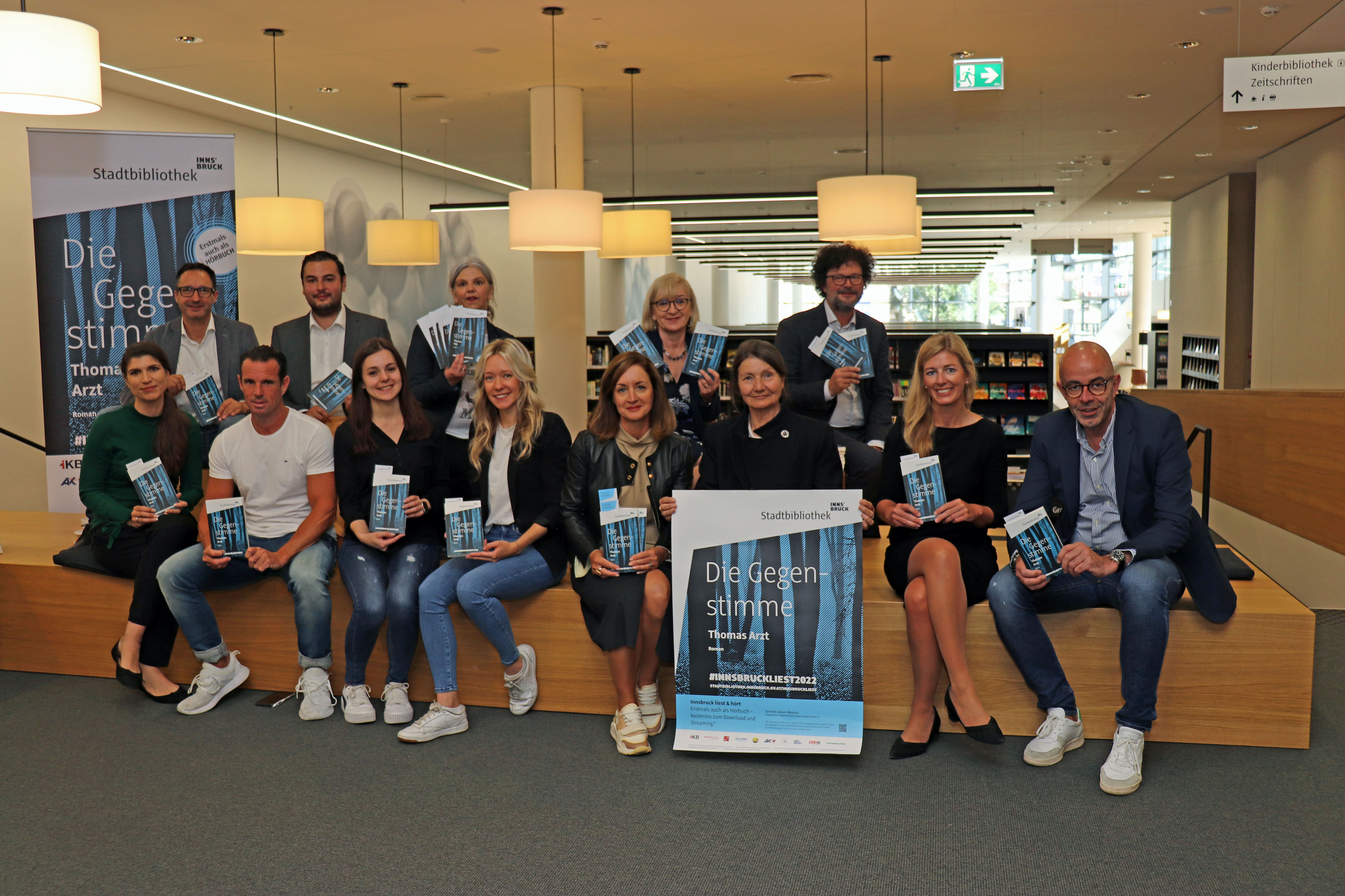 2022 heißt es erstmals „Innsbruck liest und hört“: Kulturstadträtin Uschi Schwarzl (vorne, 3. v.r.), die Leiterin der Stadtbibliothek Innsbruck, Christina Krenmayr (hinten, 3. v.l.) und Landesrätin Beate Palfrader (hinten, 2. v.r.) mit weiteren SponsorInnen präsentieren die Aktion „Innsbruck liest 2022“.