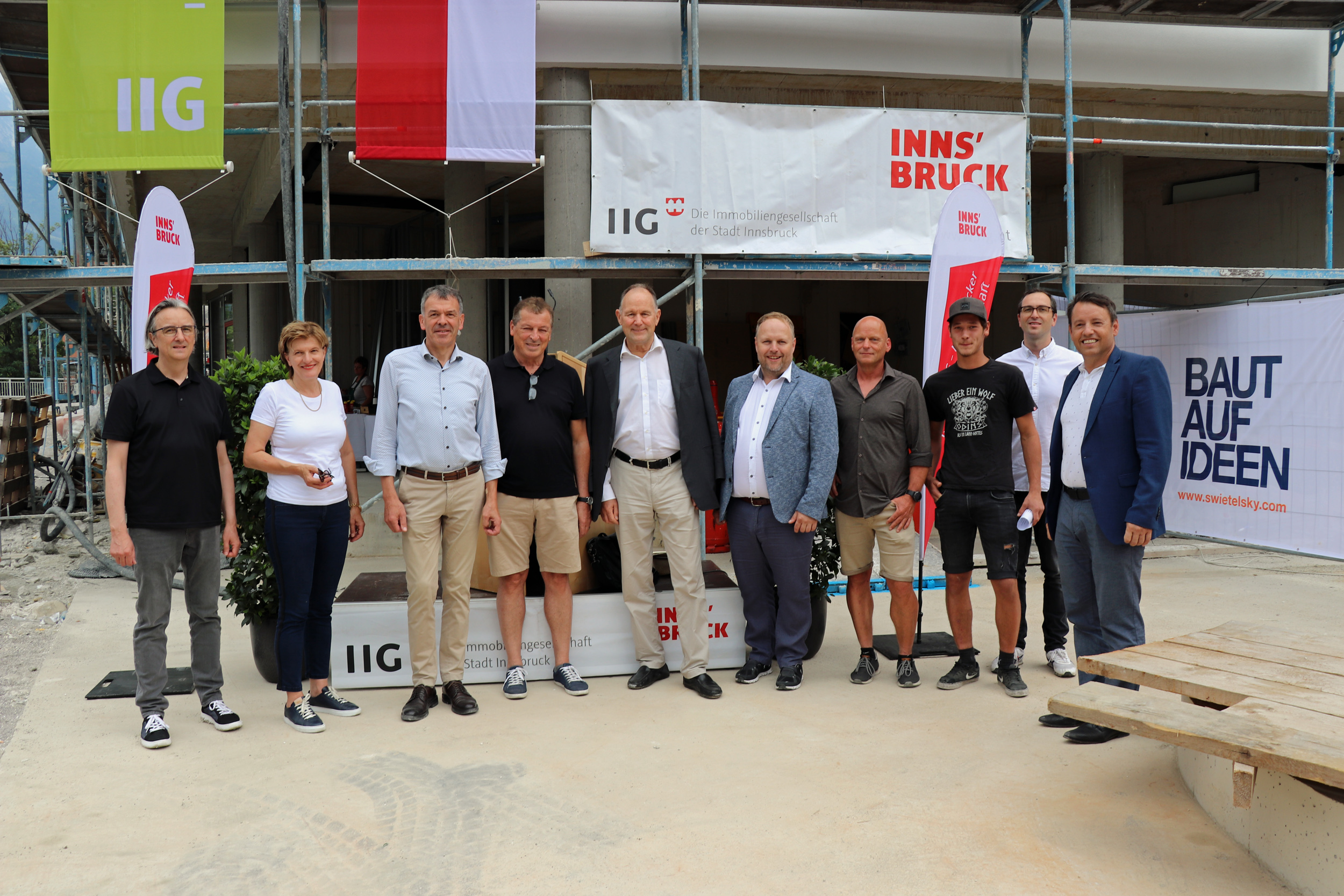 Architekt Andreas Scharmer, Stadträtin Christine Oppitz-Plörer, Bürgermeister Georg Willi, Gemeinderat Helmut Buchacher, IIG-Aufsichtsratsvorsitzender Franz Pegger, Gemeinderat Lucas Krackl, Vertreter der ausführenden Baufirma Swietelsky, Architekt Gabriel Stotter (hinten) und IIG-GF Franz Danler (v.l.n.r.) freuten sich über die gelungene Firstfeier der Wohnanlage in der Amraser Straße 26.