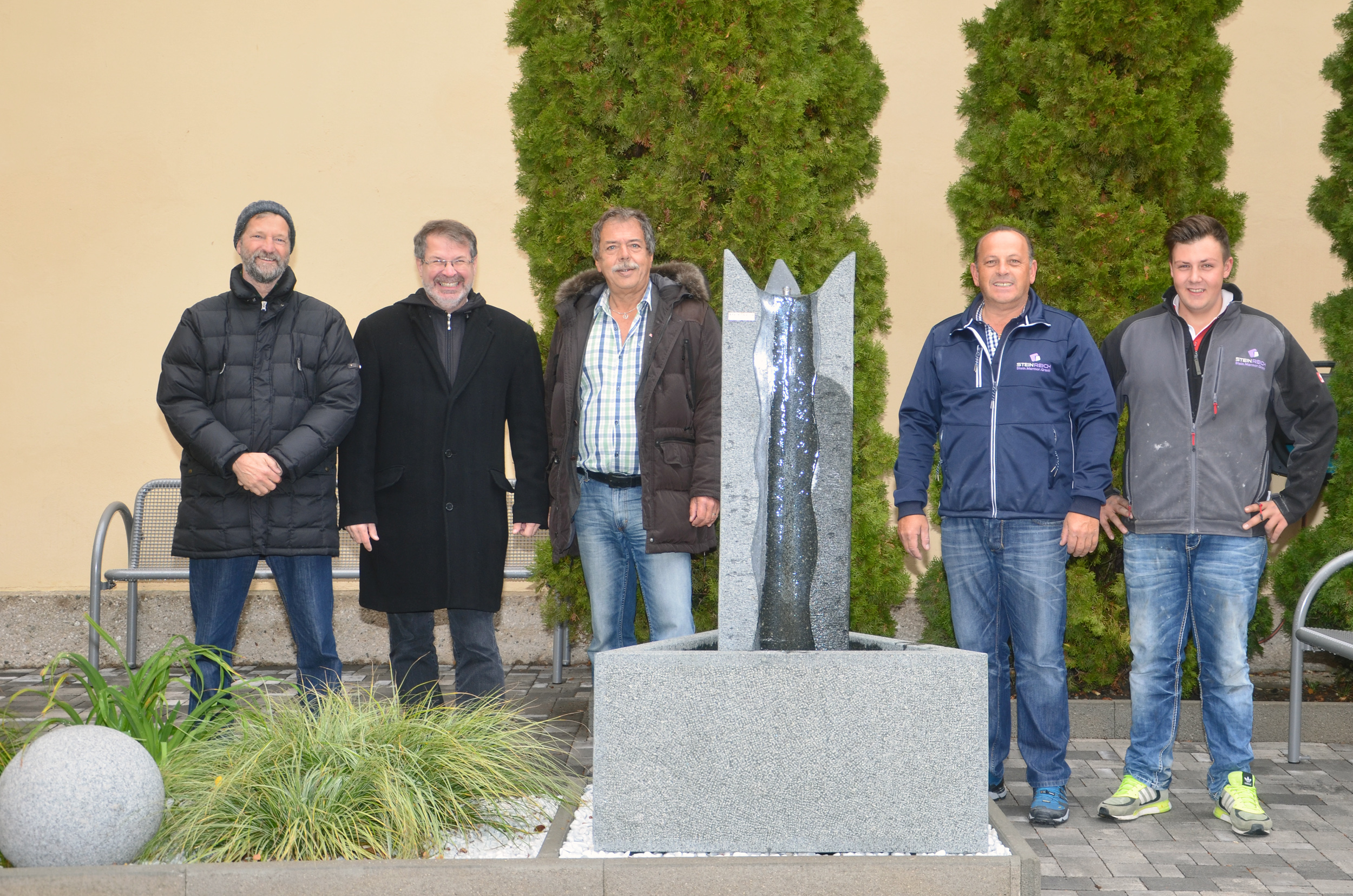 Liebevoll wurde der Vorplatz des Aufbahrungsbereiches gestaltet (v.l.): Mitarbeiter Grünanlagen – Planung und Bau - Peter Brandsma, Referatsleiter für städtische Friedhöfe Alexander Legniti, Stadtrat Gerhard Fritz und das Team von der Firma Steinreich – Franz und Lukas Reich