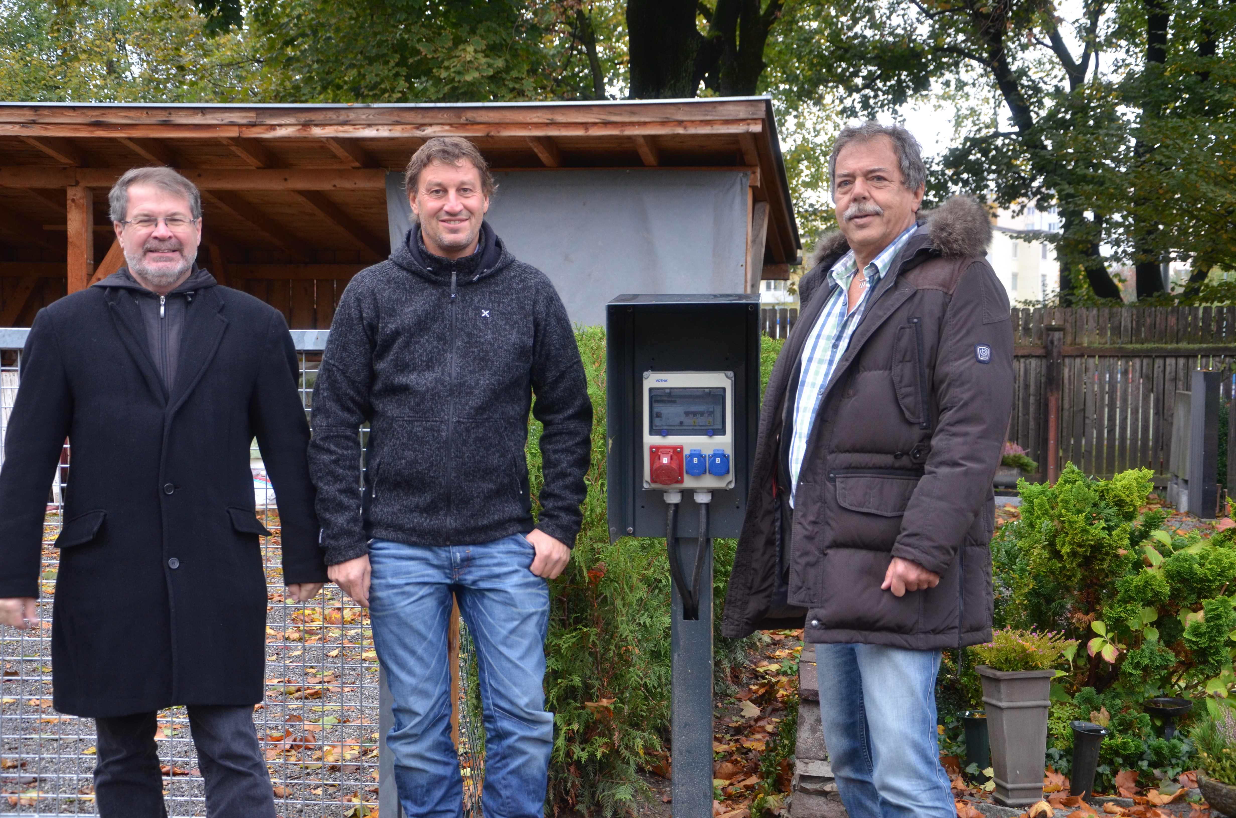 Stromanschlüsse wie dieser bringen enorme Erleichterungen für die Mitarbeiterinnen am städtischen Westfriedhof (v.l.): Referatsleiter städtische Friedhöfe Alexander Legniti, Teamleiter Instandhaltung der IIG Martin Kiechl und Stadtrat Gerhard Fritz