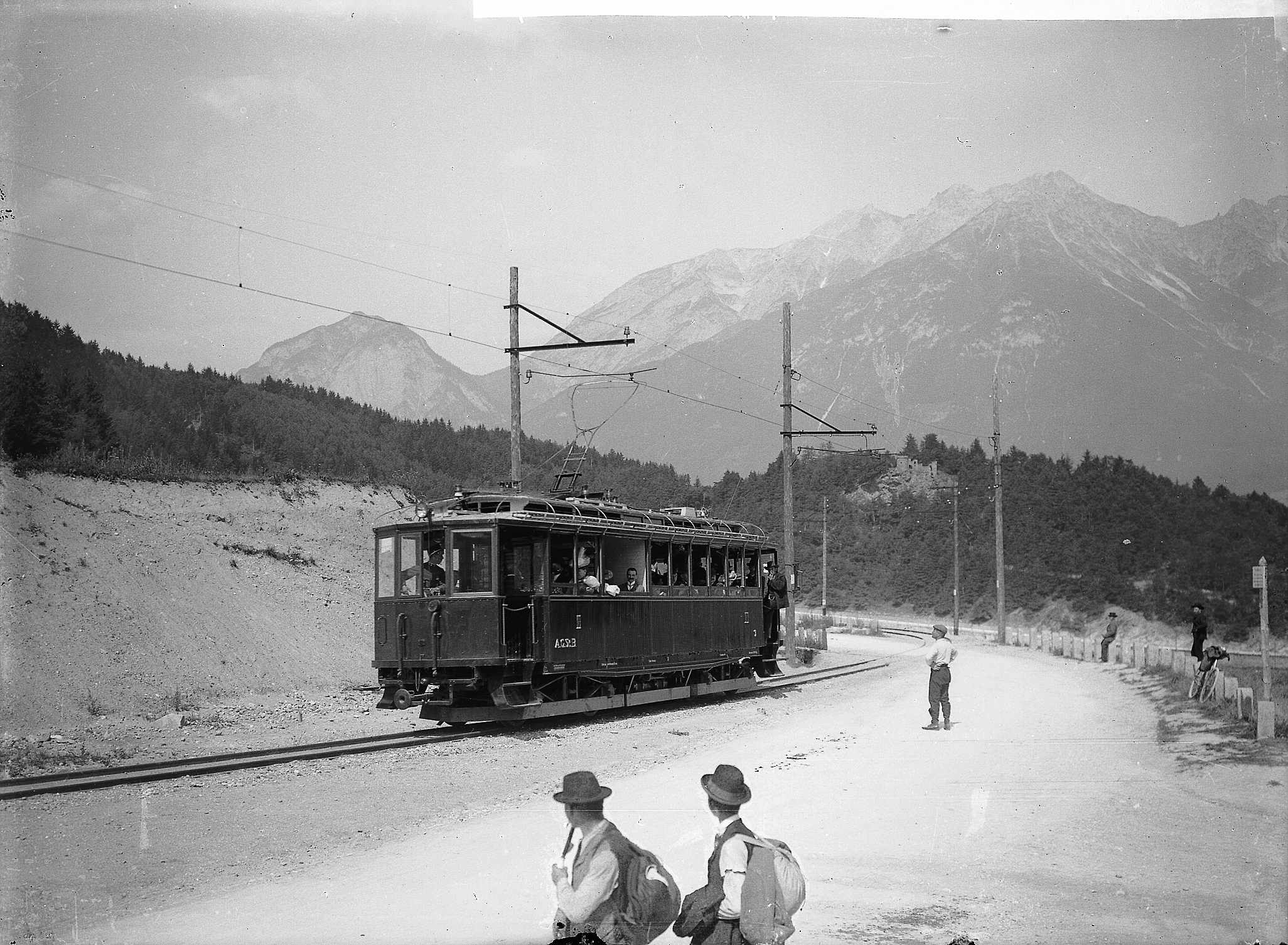 Triebwagen der Stubaitalbahn, rechts die Brennerstraße mit einigen Wanderern