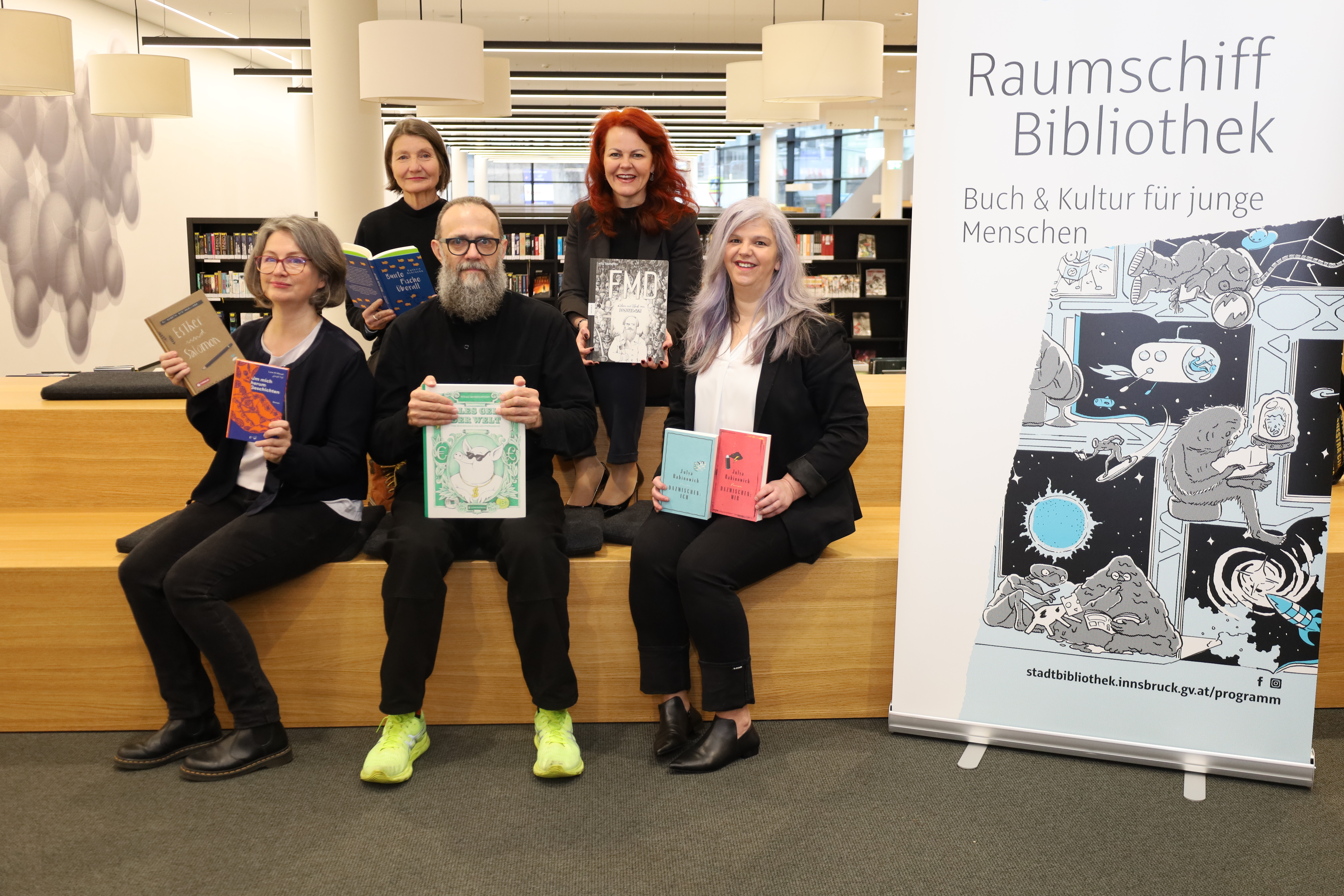Vitali Konstantinov stellt als einer der AutorInnen bei "Raumschiff Bibliothek" seine Comic-Sachbücher vor: Mit (v.l.) Veronika Knapp (Projektleiterin), Stadträtin Uschi Schwarzl, Landesrätin Cornelia Hagele und Bibliotheksleiterin Christina Krenmayr.