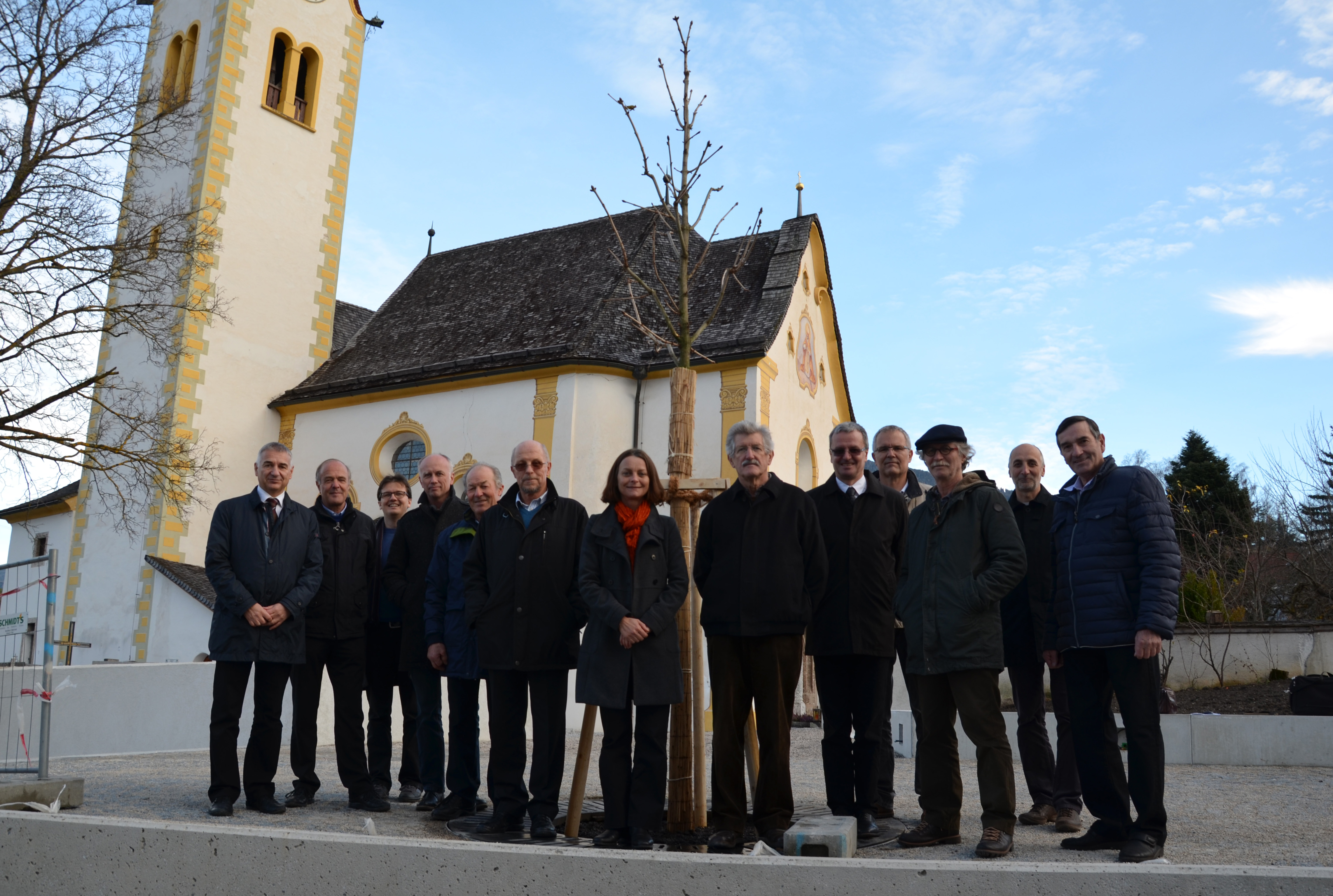 Vizebürgermeisterin Mag.a Sonja Pitscheider (Mitte) positioniert sich stolz vor dem neu-gepflanzten Kastanienbaum. DI Walter Zimmeter (Amt Tiefbau), Ing. Martin Mayr (Amt Tiefbau), DI. Markus Pinter (Amt für Grünanlagen), DI Michael Felder (Architekt), Johann Eisendle, Ing. Ewald Dworschak, Dr. Max Profanter, Dr. Klaus Jenewein, Wolfgang Gritsch, Dr. Thomas Parth (alle Unterausschuss Vill), Christian Schoder (Amt Tiefbau) und Franz Wopfner (Unterausschuss Vill) freuten sich ebenfalls über den Baumzuwachs.