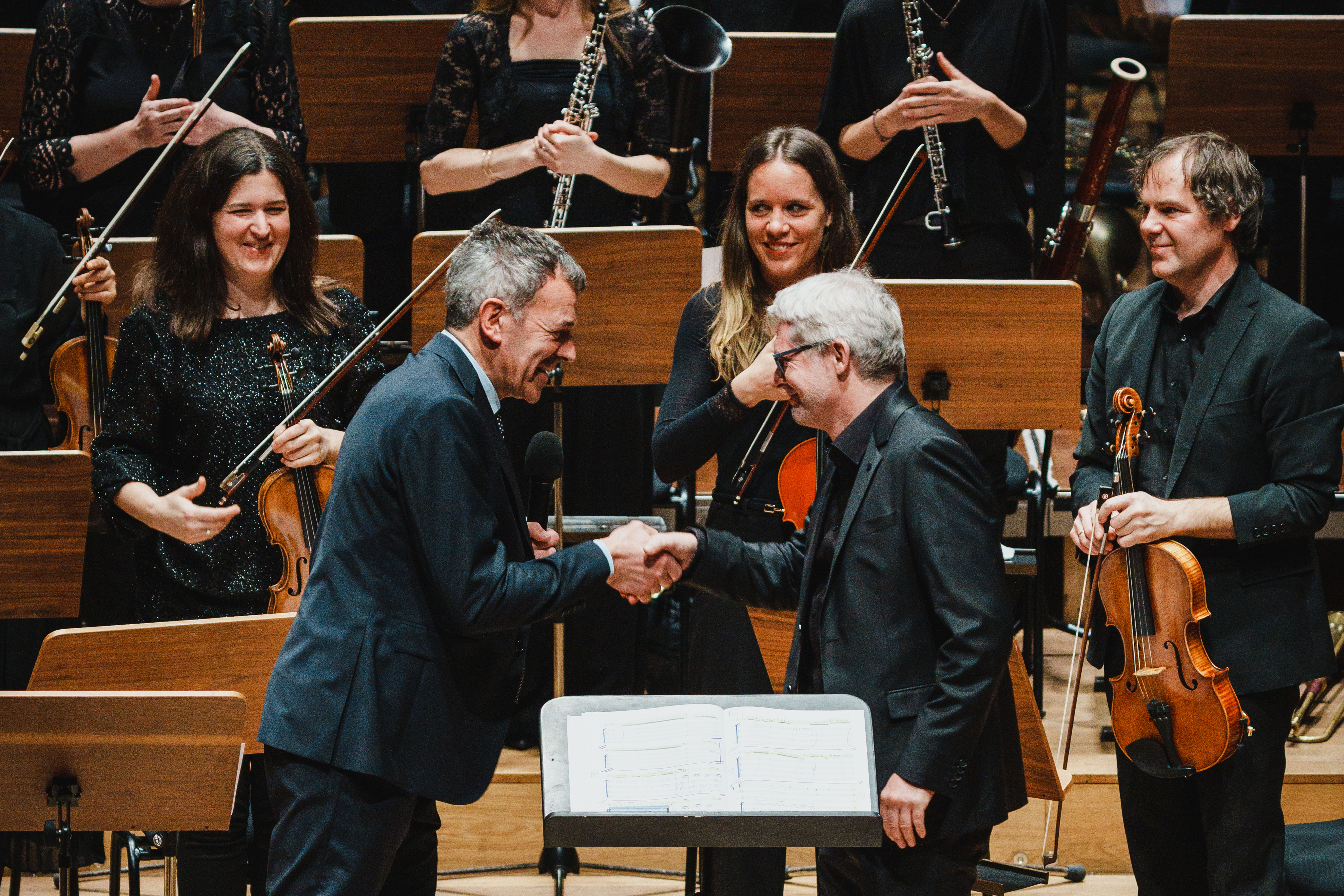 Bürgermeister Georg Willi (l.) gratuliert Dirigent Gerhard Sammer zum Erhalt des Ehrenzeichens für Kunst und Kultur der Stadt Innsbruck.