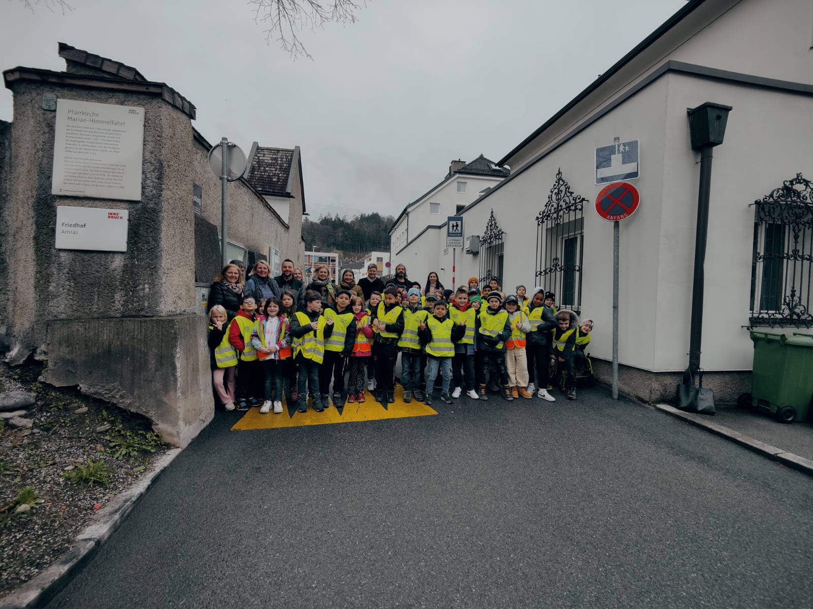 Stadträtin Elisabeth Mayr (6. v. l.), Stadträtin Uschi Schwarzl (7. v. l.), Schuldirektorin Monika Strobl (8. v. l.), Ersatz-GR Marco Frei (9. v. l.), VertreterInnen der ARGE und des Elternvereins sowie die Schulkinder der VS Amras freuen sich über die neue Schulstraße.