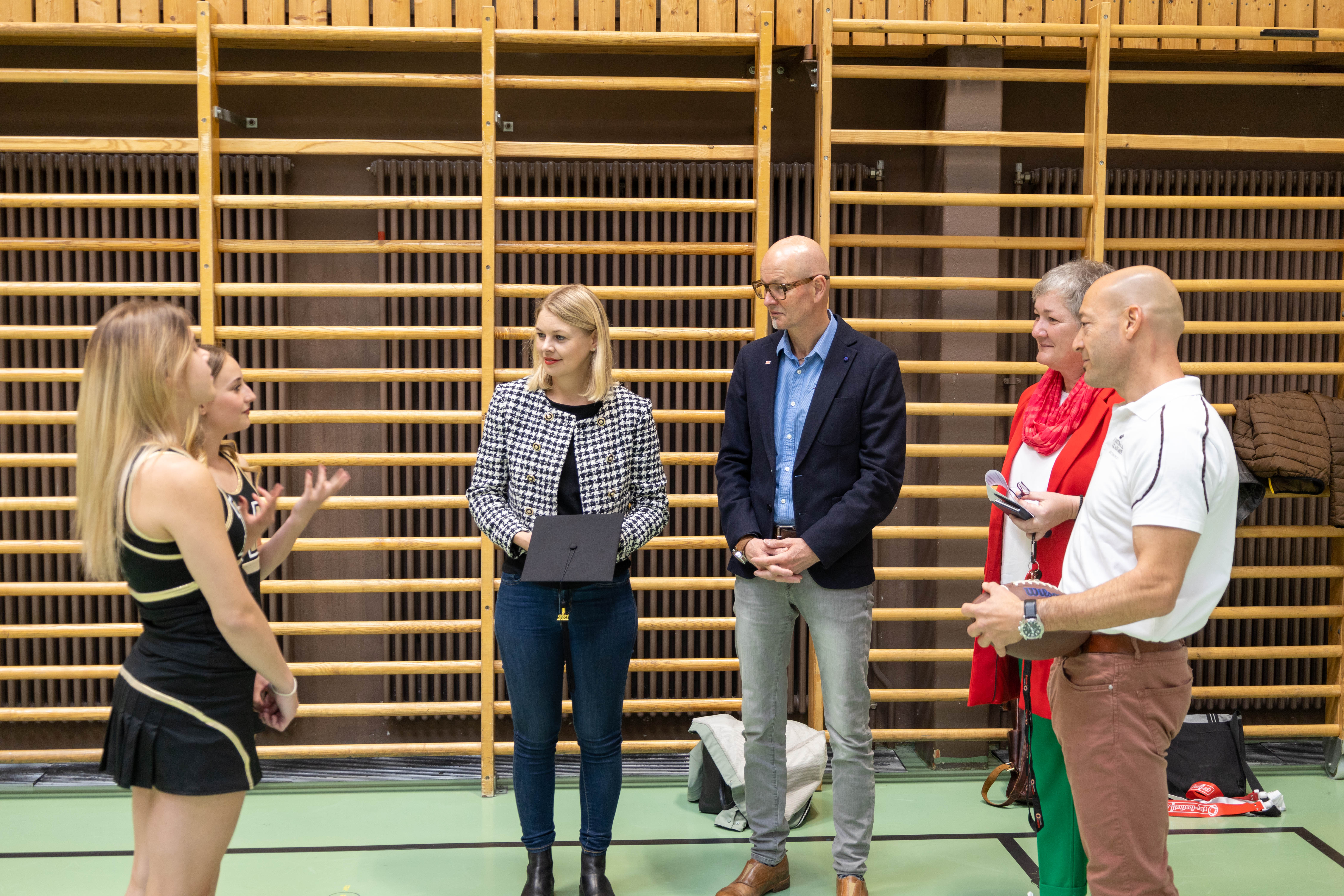 Zwei Cheerleaderinnen beim Austausch über ihr sportliches Schulprogramm.