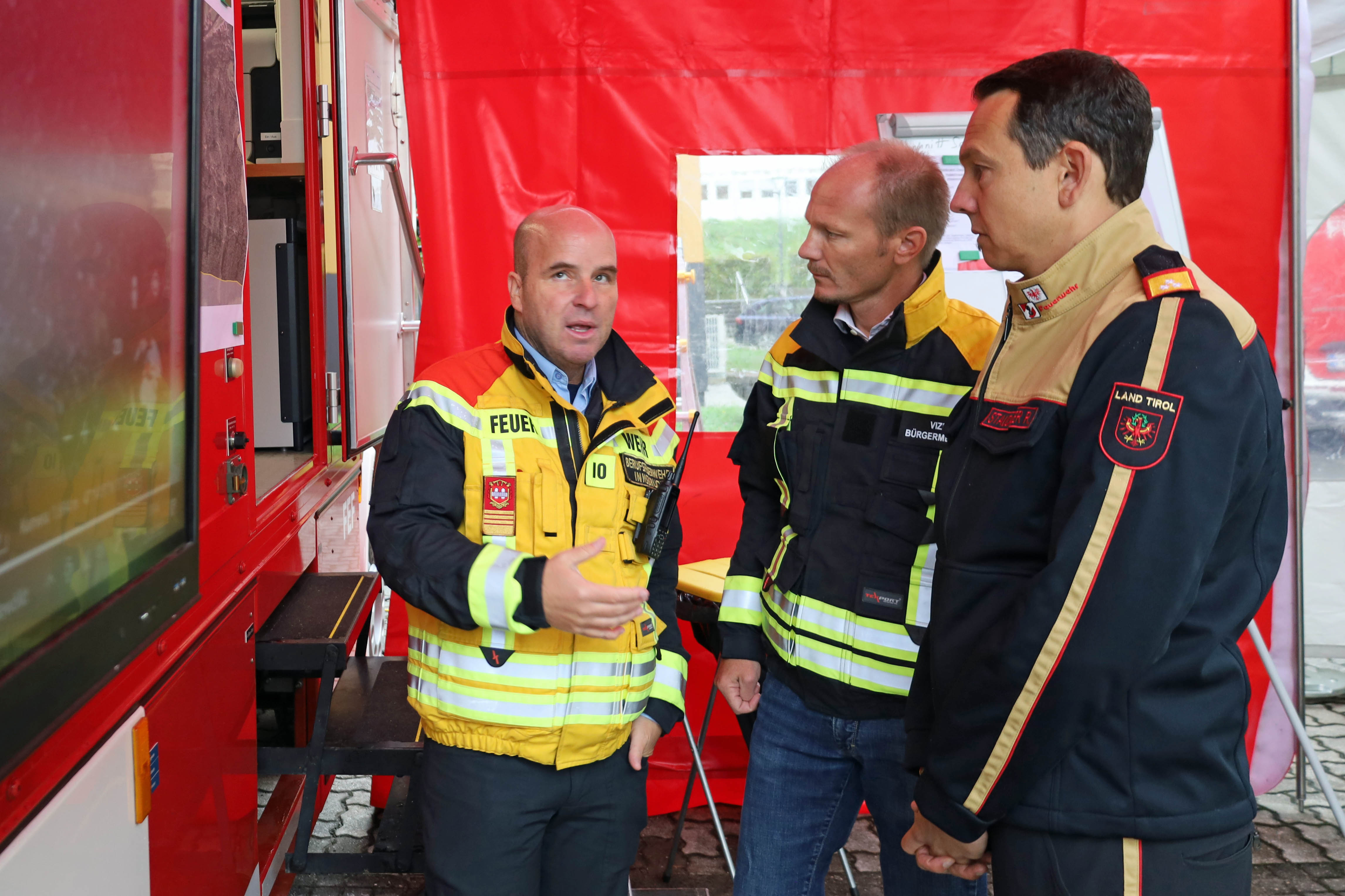Vizebürgermeister Johannes Anzengruber (m.), Einsatzleiter Marcus Wimmer (l.) und der designierte Tiroler Landesfeuerwehrinspektor René Staudacher (r.) besprechen die Lage bei der Einsatzleitung in der Standschützenkaserne.