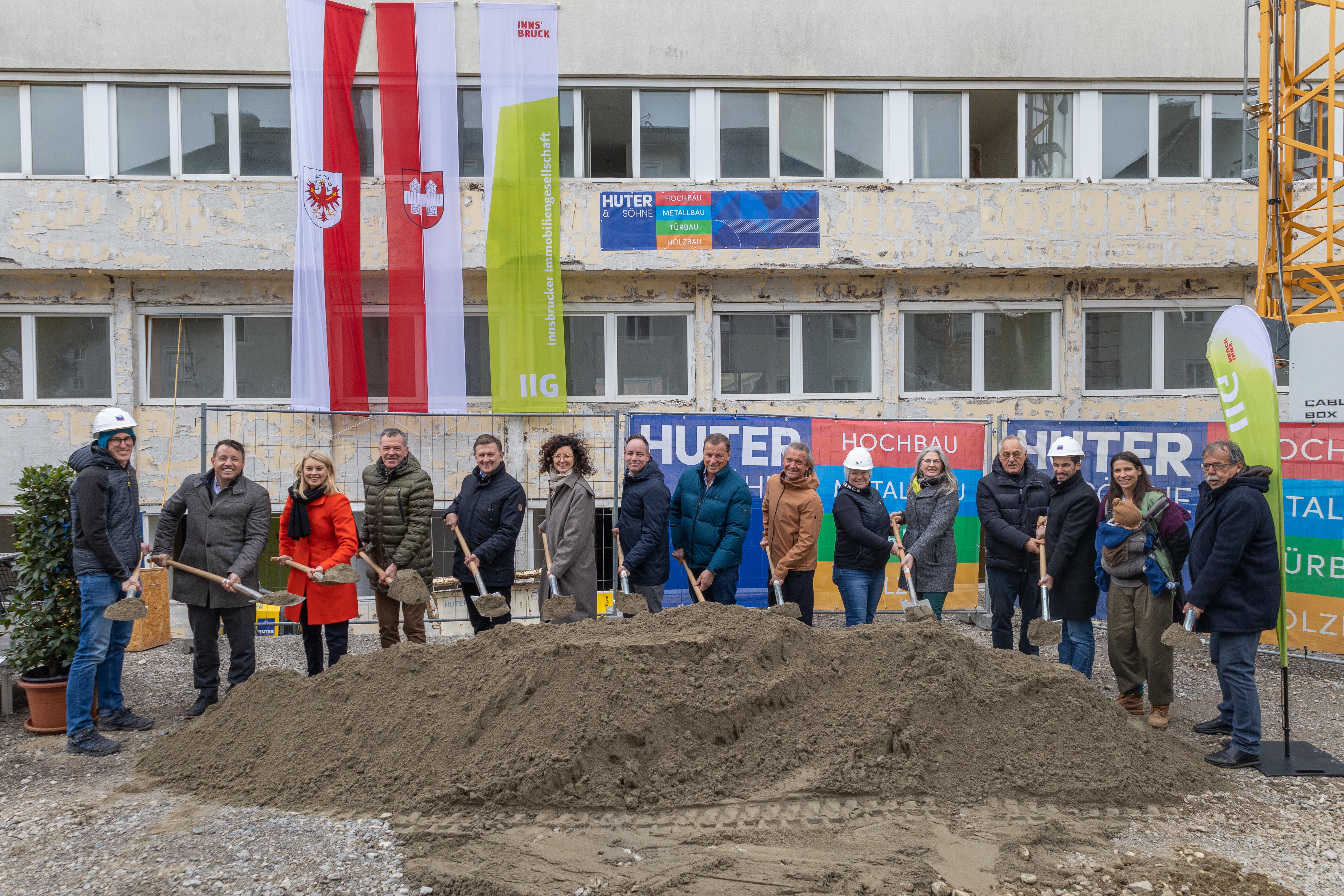 Freuten sich, dass die Bauarbeiten für das zukünftige Betreuungs- und Beratungszentrum am Domanigweg starten: (v. l.:) IIG-Geschäftsführer Franz Danler, (2. v. l.). Frauenstadträtin Elisabeth Mayr, Bürgermeister Georg Willi, Reinhard Halder (Geschäftsführer Jugendland), Julia Schratz (Geschäftsführerin lilawohnt), Vizebürgermeister Markus Lassenberger, Gemeinderat Helmut Buchacher, Jasmine Rosa Hangl (Projektleiterin IIG, 5. v. r.), Gemeinderat Thomas Schultze, Gemeinderätin Janine Bex, Gemeinderat Gerhard Fritz sowie Mitarbeitende der IIG und der bauausführenden Betriebe.