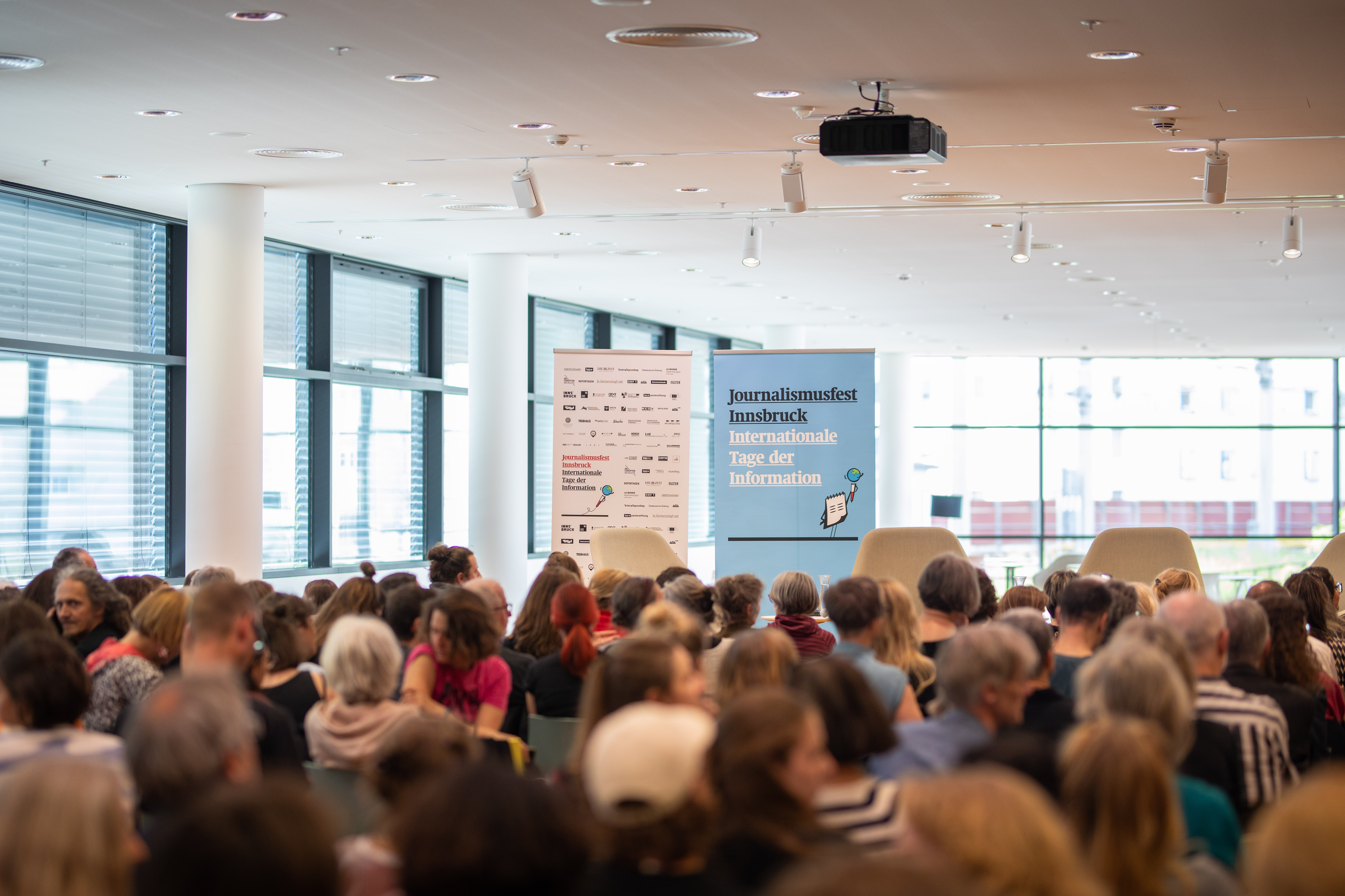 Veranstaltungen wie hier das Journalismusfest 2023 locken nicht nur im Mai viele BesucherInnen in den 1. Stock der Stadtbibliothek Innsbruck.