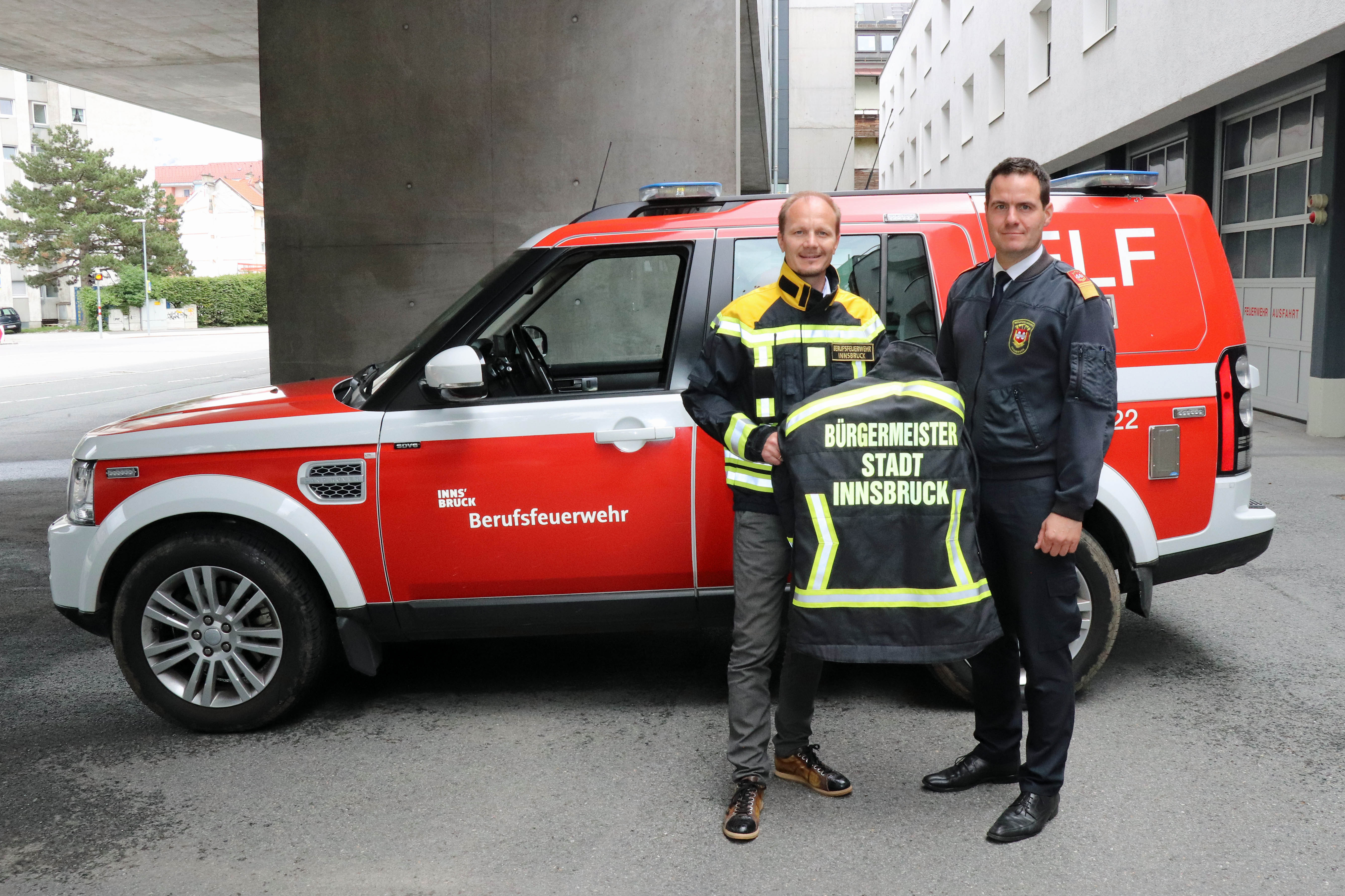 Bürgermeister Johannes Anzengruber (l.) und Branddirektor Helmut Hager bei der offiziellen Übergabe der Einsatzjacke vor der Hauptfeuerwache der Berufsfeuerwehr.