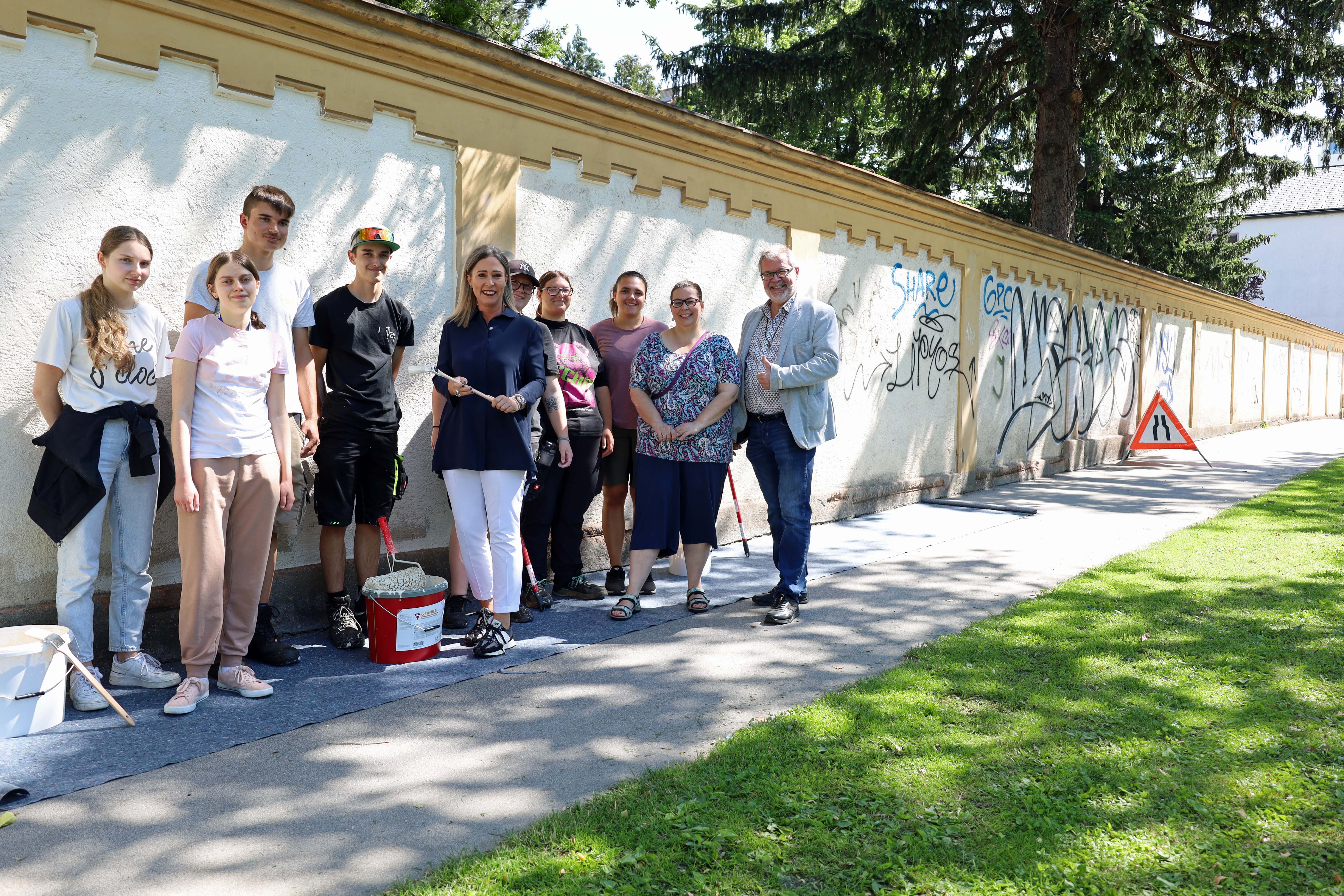 Mit vielen helfenden Händen geht es schneller: Die Lehrlinge, die die Friedhofsmauern von den Schriftzügen befreiten, mit Stadträtin Mariella Lutz (5. v.l.), Sabine Floßmann und Alexander Legniti (2. bzw. 1. v.r.).