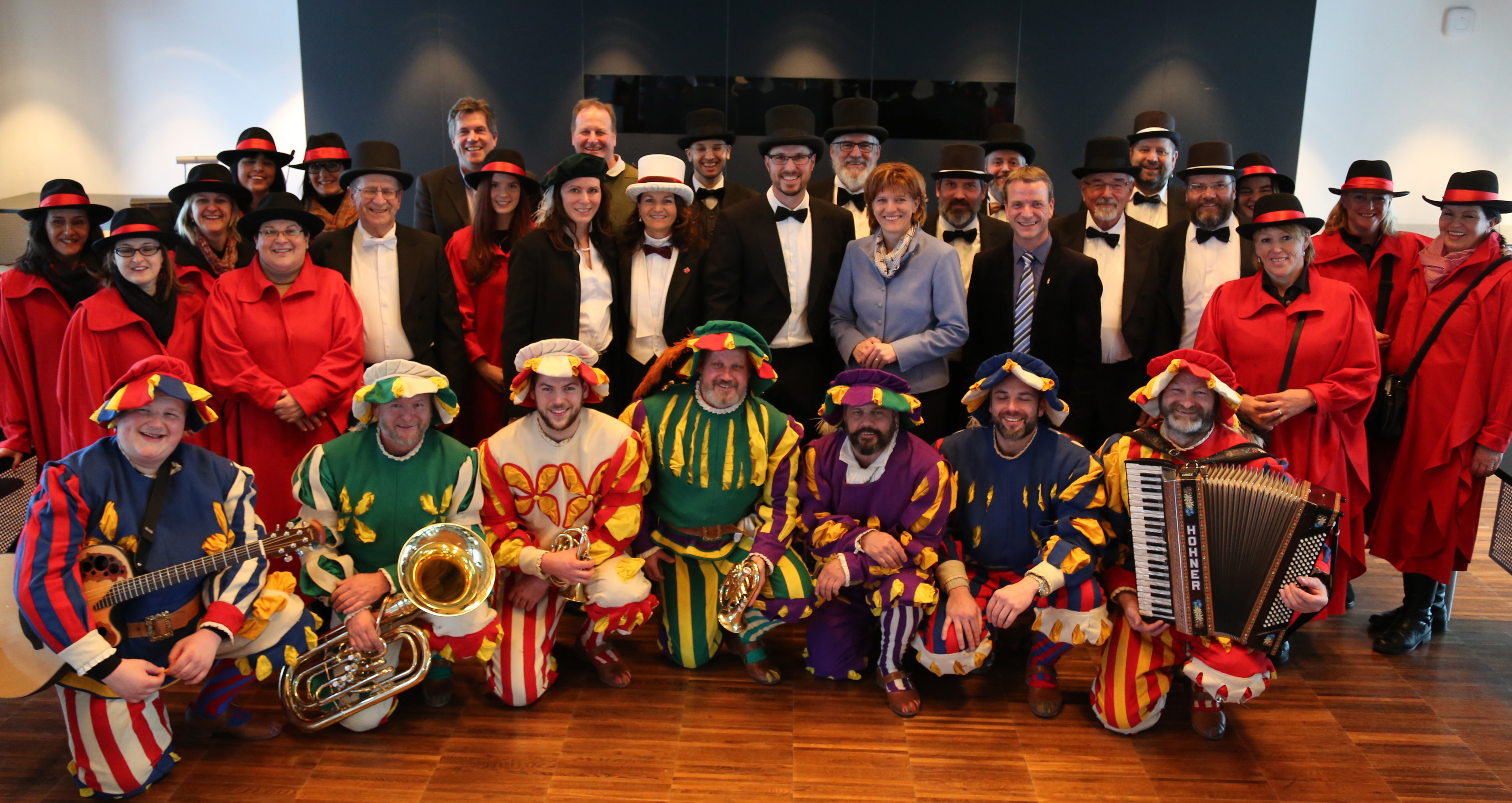 Fasnachtsobmann Christian Härting (Bildmitte), Bürgermeisterin Christine Oppitz-Plörer und Vizebürgermeister Christoph Kaufmann inmitten des Faschingskomitees, den bunten Herolden und den rot gekleideten Gotl´n im Plenarsaal des Innsbrucker Rathauses.