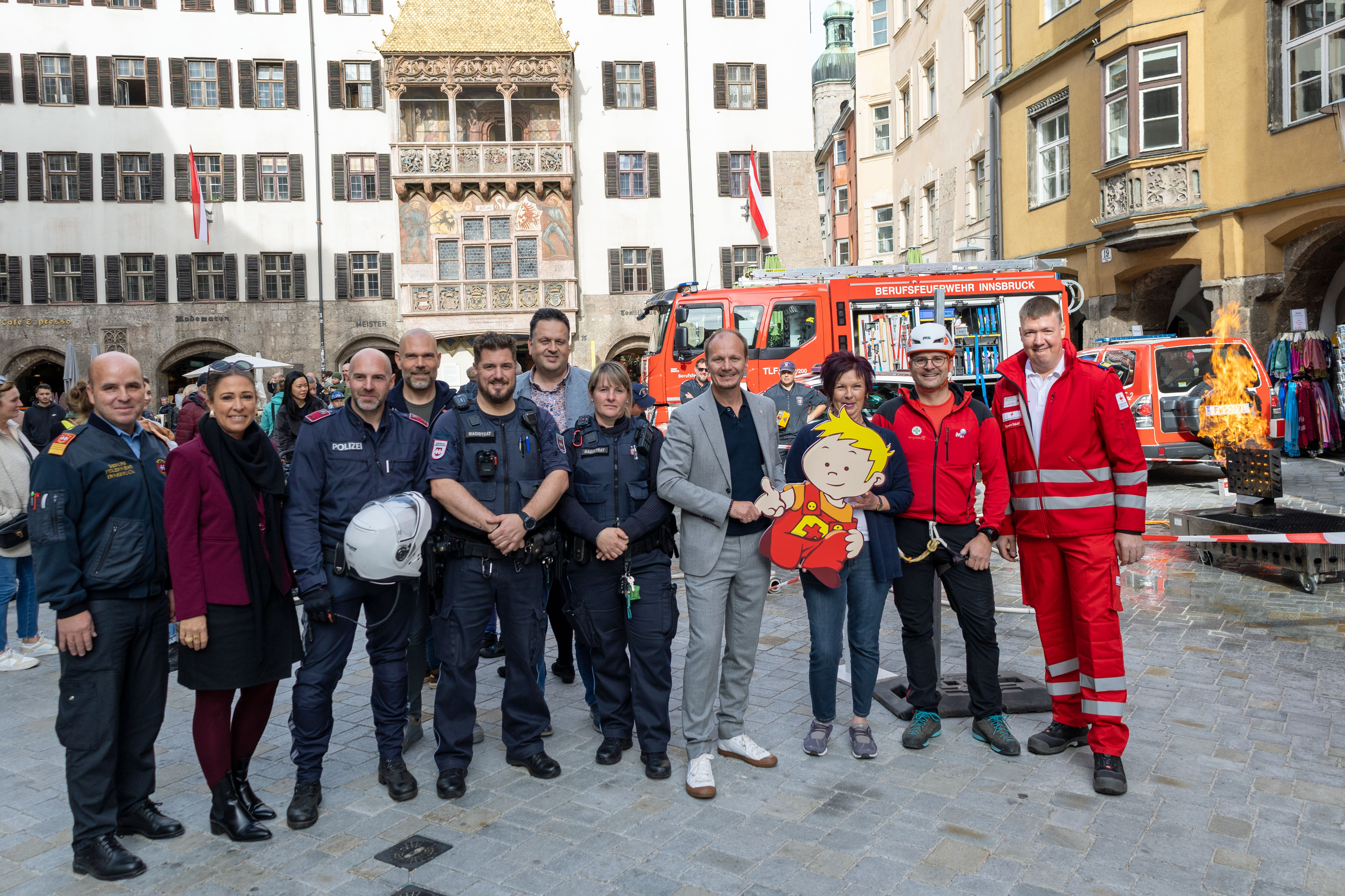 Bürgermeister Johannes Anzengruber, (4.v.r.), Stadträtin Mariella Lutz (2.v.l.), Referentin Uschi Klee (3.v.r.), Amtsvorstand Christian Schneider (6.v.r.) und André Lomsky (Innsbruck Tourismus, 4.v.l.) freuen sich gemeinsam mit den VertreterInnen der Innsbrucker Berufsfeuerwehr, der Polizei, der MÜG, des Roten Kreuzes und der Bergrettung über ein gelungenes „Peterle hilft“-Fest.