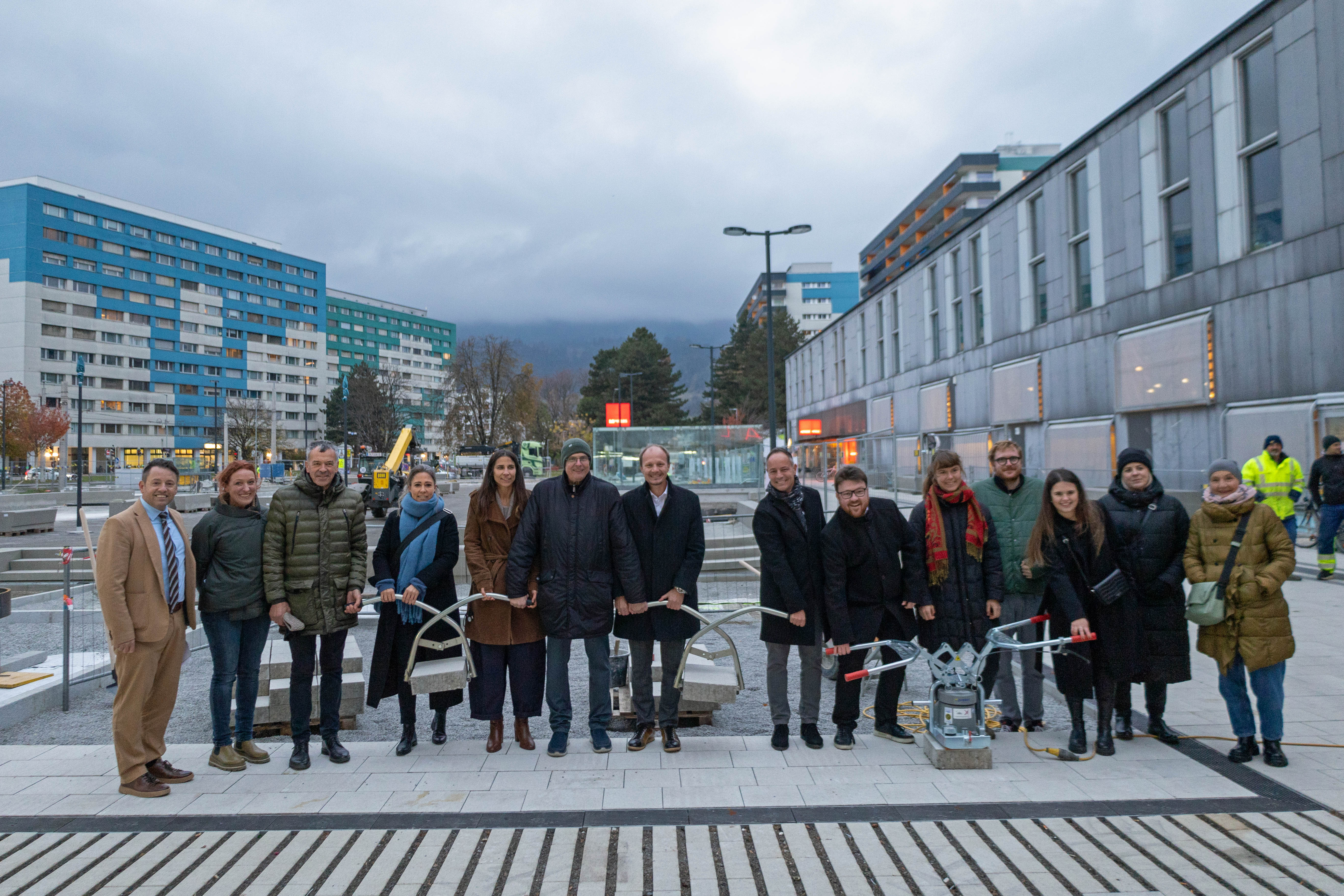 Bürgermeister Johannes Anzengruber (7.v.l.), Vizebürgermeister Georg Willi (3.v.l.), Stadträtin Janine Bex (5.v.l.), Stadträtin Mariella Lutz (4.v.l.), Stadtrat Markus Lassenberger (8.v.l.) und Mitglieder des Gemeinderats freuen sich mit IIG-Geschäftsführer Franz Danler (l.), Projektleiterin Christine Schermer (2.v.l.) und der ehemaligen Stadträtin Uschi Schwarzl (r.) beim COOLYMP-Baustellenfest über den Baufortschritt.