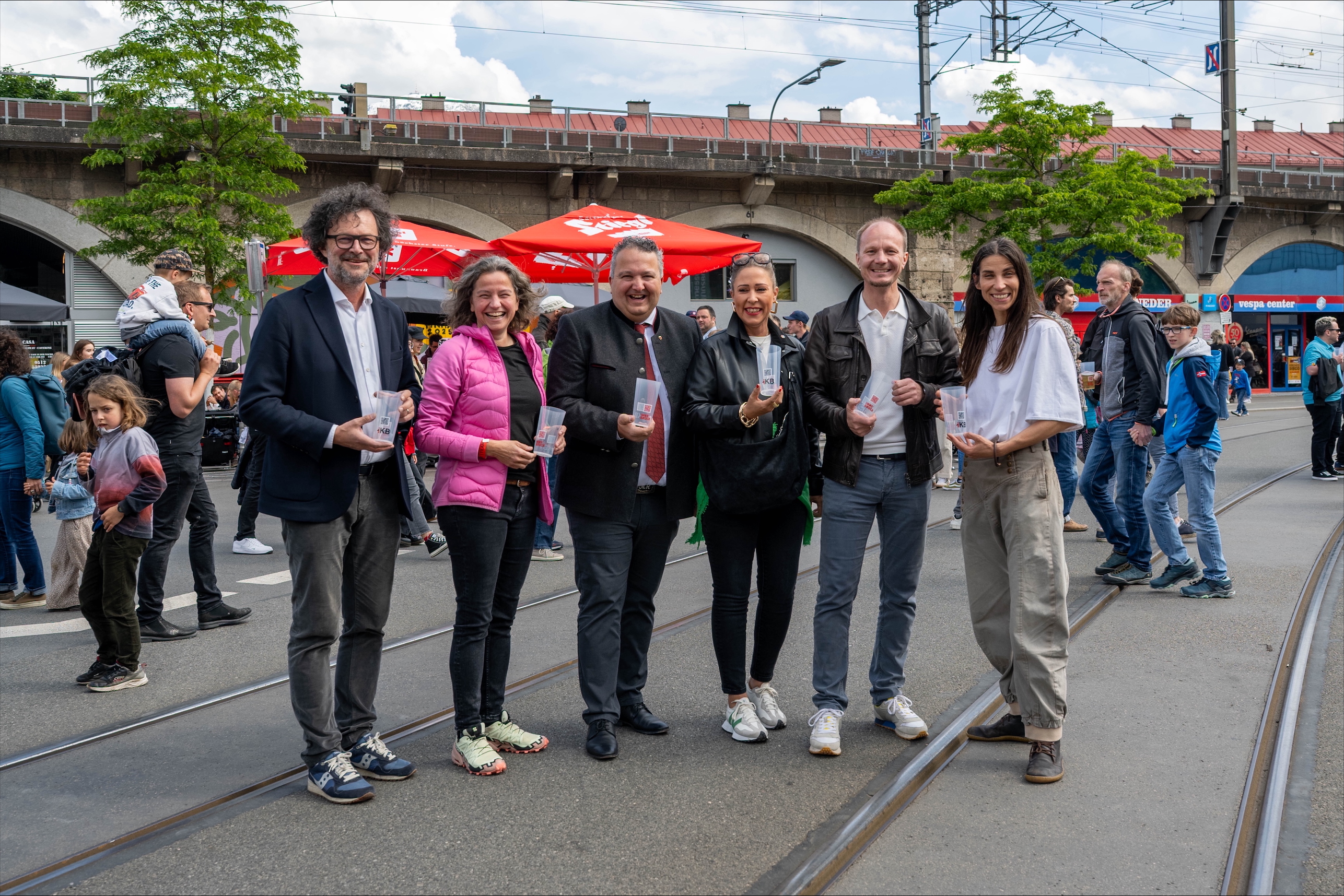 Nagelprobe bestanden - Die Mehrwegbecher der Innsbrucker Kommunalbetriebe AG (IKB) kamen erstmals großflächig beim Bogenfest am 24. Mai 2025 in Innsbruck zum Einsatz: v.l. Thomas Pühringer (IKB-Vorstand), Heike Kiesling (Geschäftsführerin Innsbruck Marketing),  Klaus Mair (Geschäftsführer der GW Tirol), Stadträtin Mariella Lutz, Bürgermeister Johannes Anzengruber, Stadträtin Janine Bex.