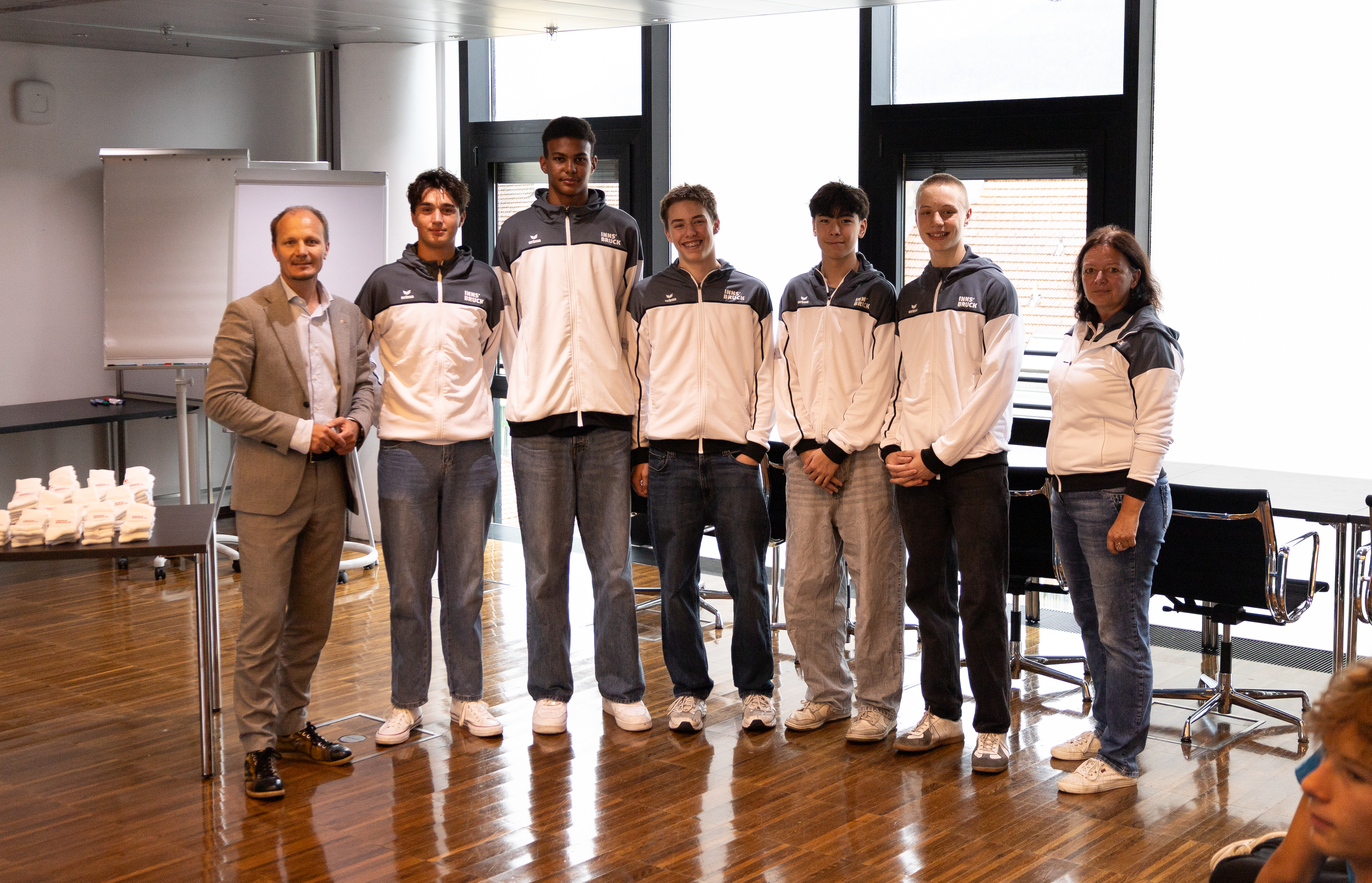 Bürgermeister Johannes Anzengruber (l.) und Angelika Neuner (Sportamt, r.) mit den Innsbrucker Sportlern vor dem Aufbruch zu den Children’s Games nach Tallinn.