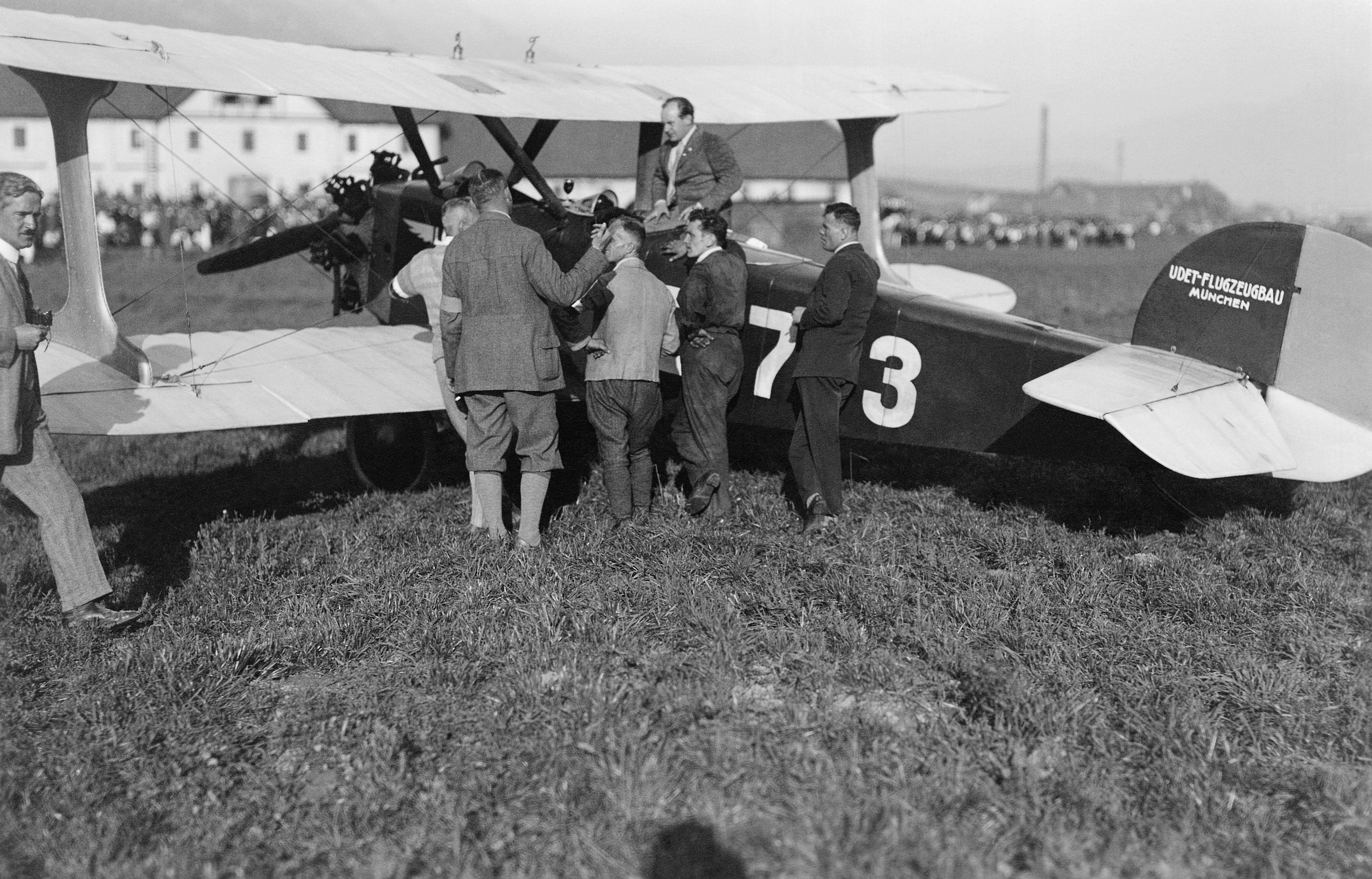 Ernst Udet (auf der Maschine sitzend) und fünf Männer
mit dem Doppeldecker Udet U 12 „Flamingo“ auf dem
Flughafen Reichenau.
