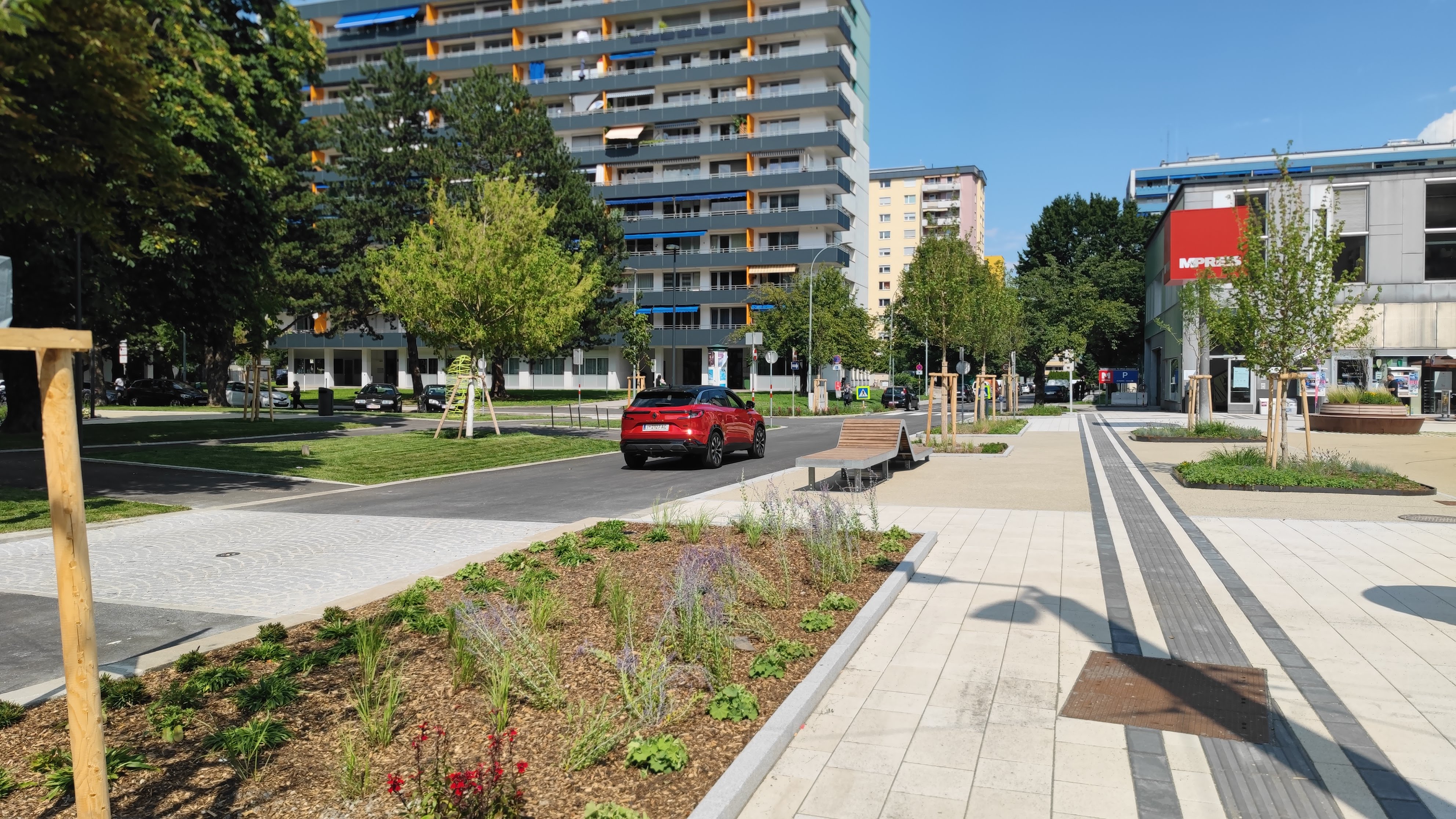 Die neugestaltete An-der-Lan-Straße verbindet DDr.-Alois-Lugger-Platz und Olympiapark barrierefrei mit mehr Grün, Sitzgelegenheiten und Raum für Begegnung.