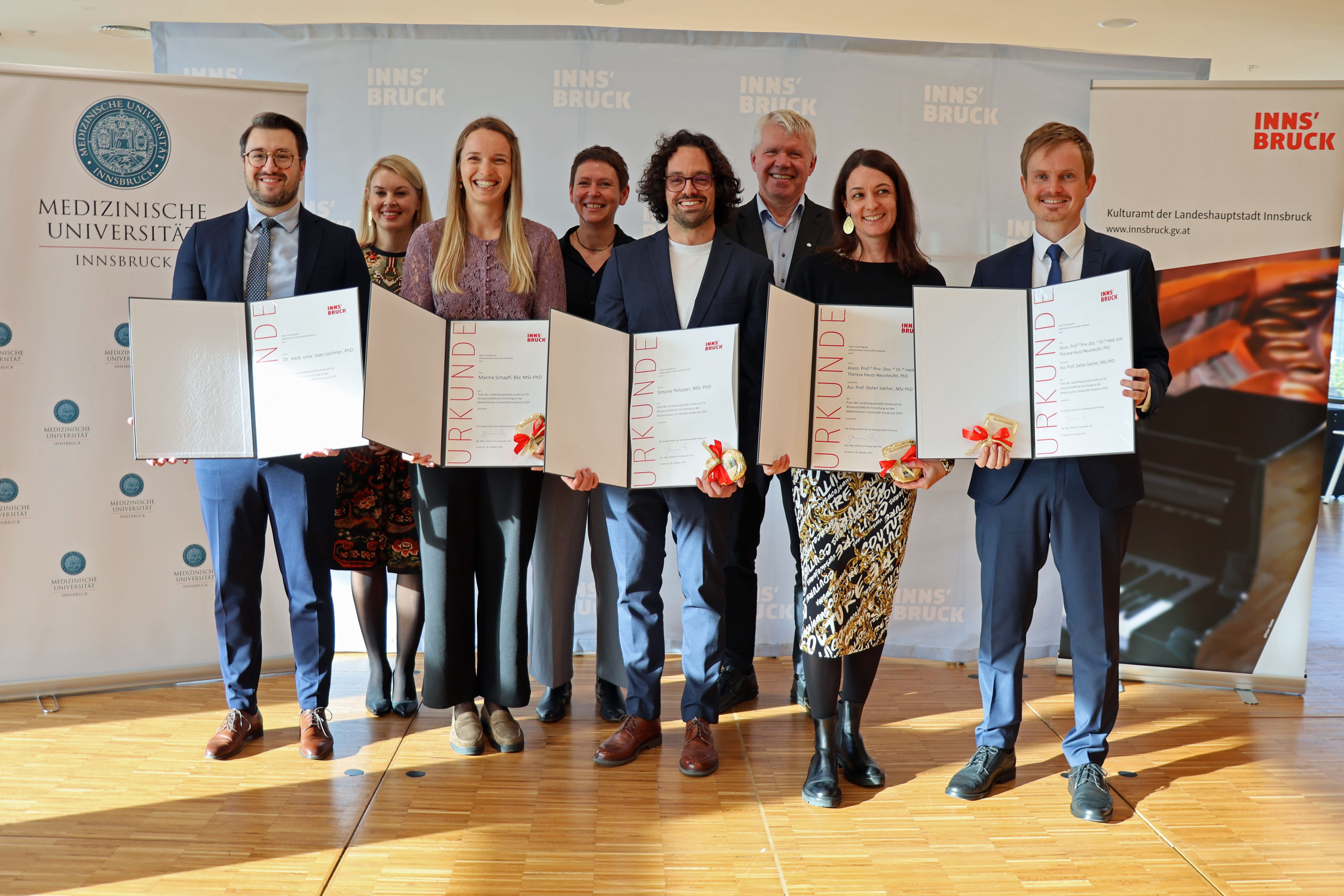 Vizebürgermeisterin Elisabeth Mayr (hinten links), Rektor der Medizinischen Universität Gert Mayer (hinten rechts) und Patrizia Stoitzner, Vizerektorin für Forschung und Internationales an der Med-Uni Innsbruck, freuen sich mit den diesjährigen PreisträgerInnen Ivan Lechner, Marina Schapfl, Simone Pelizzari, Theresa Hautz-Neunteufel und Stefan Salchner.
