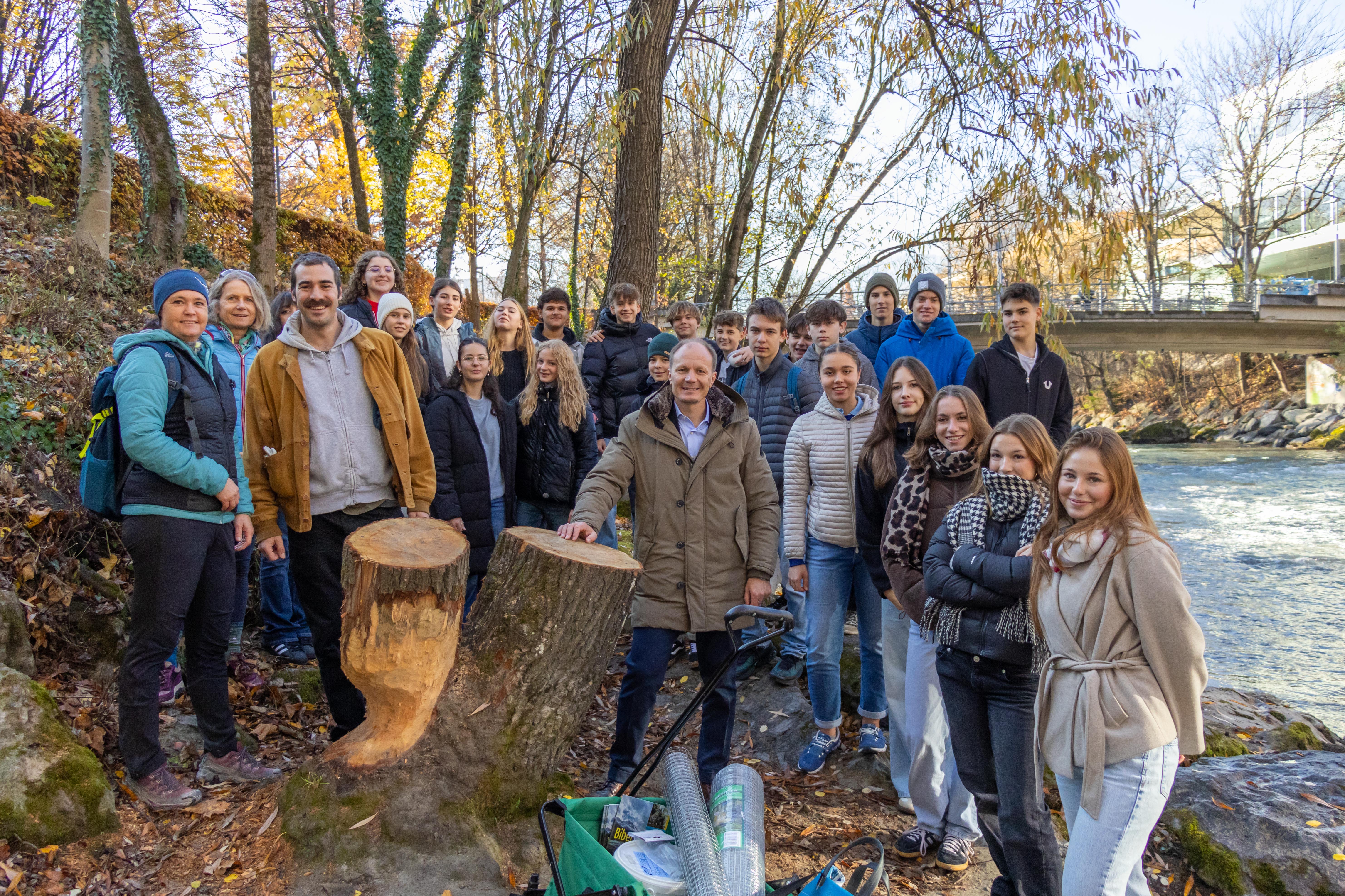 Bürgermeister Johannes Anzengruber (Mitte), Monika Eder-Trenkwalder (l.), Lehrerin Isabel Plattner (2. v. l.), Thomas Klestil (3. v. l.) und die 5. Klasse des Gymnasiums BRG in der Au schützen Uferbäume vor dem Fällen durch den Biber.