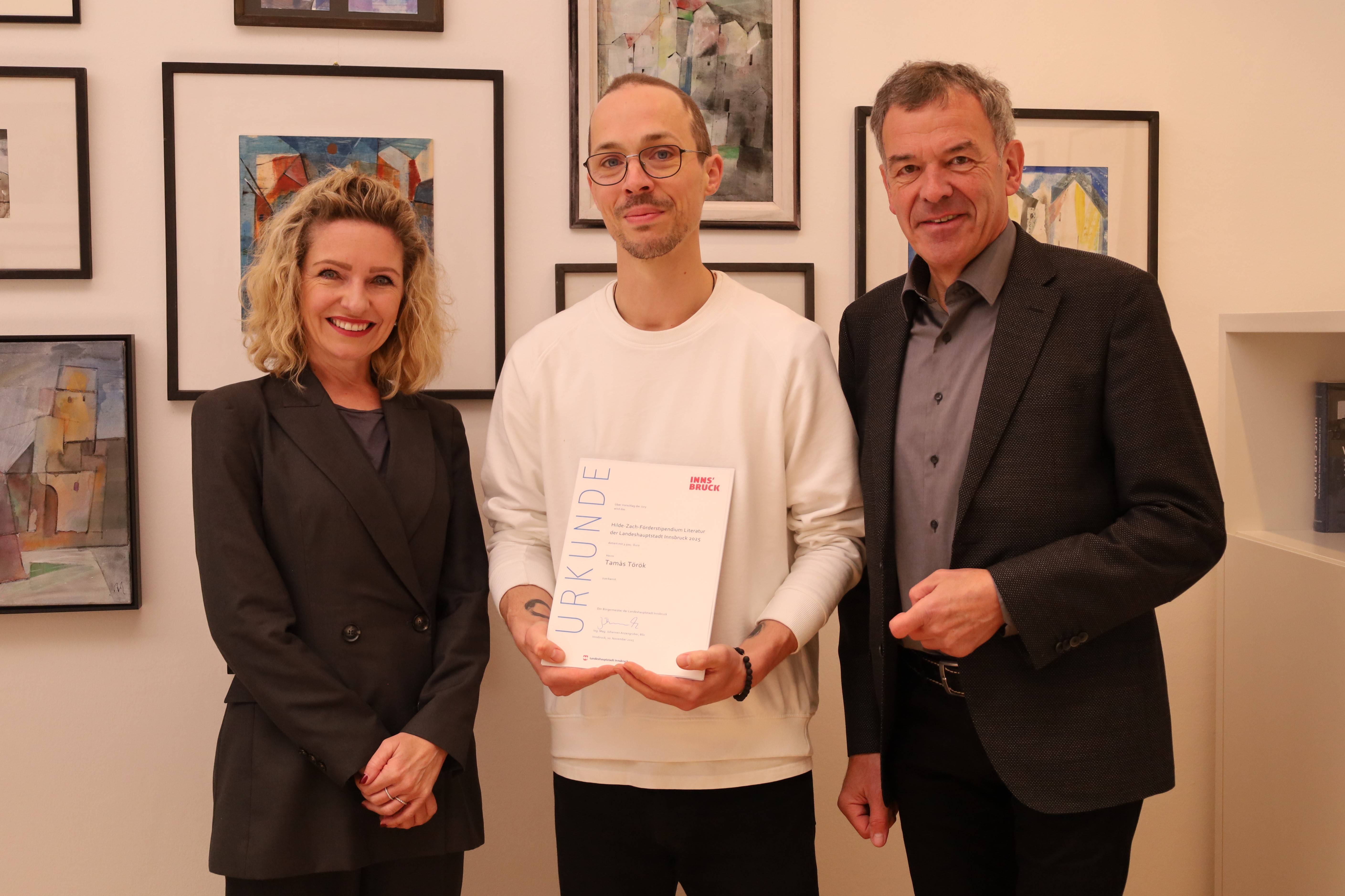 Tamás Török (m.) wurde mit dem Förderstipendium der Hilde-Zach-Literaturstipendien 2025 ausgezeichnet. Vizebürgermeister Georg Willi (r.) und Kulturamtsleiterin Isabelle Brandauer (l.) gratulierten herzlich.