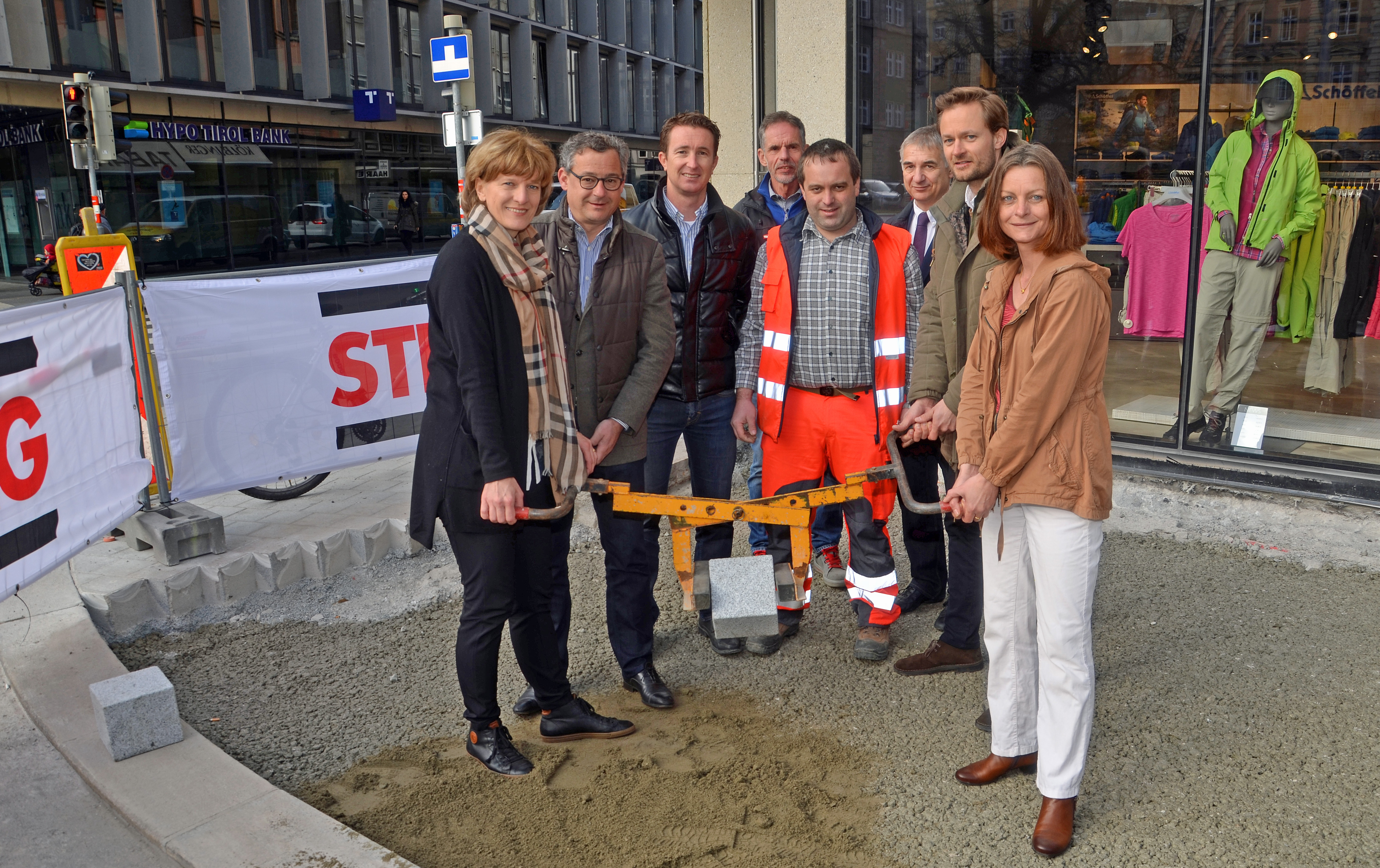 In Anwesenheit von  Thomas Hudovernik (Obmann Verein Innsbruck Innenstadt), Markus Pfeifer (Gruppenleiter Strabag), Herwig Kutter (Referent Tiefbau – Bau), Thomas Mair, Amtsvorstand Walter Zimmeter (Tiefbau) und Markus Wopfner (Verein Innsbruck Innenstadt; v. l.) legten Bürgermeisterin Christine Oppitz-Plörer (l.) und Vizebürgermeisterin Sonja Pitscheider (r.) den ersten Pflasterstein im nördlichen Bereich der Wilhelm-Greil-Straße.