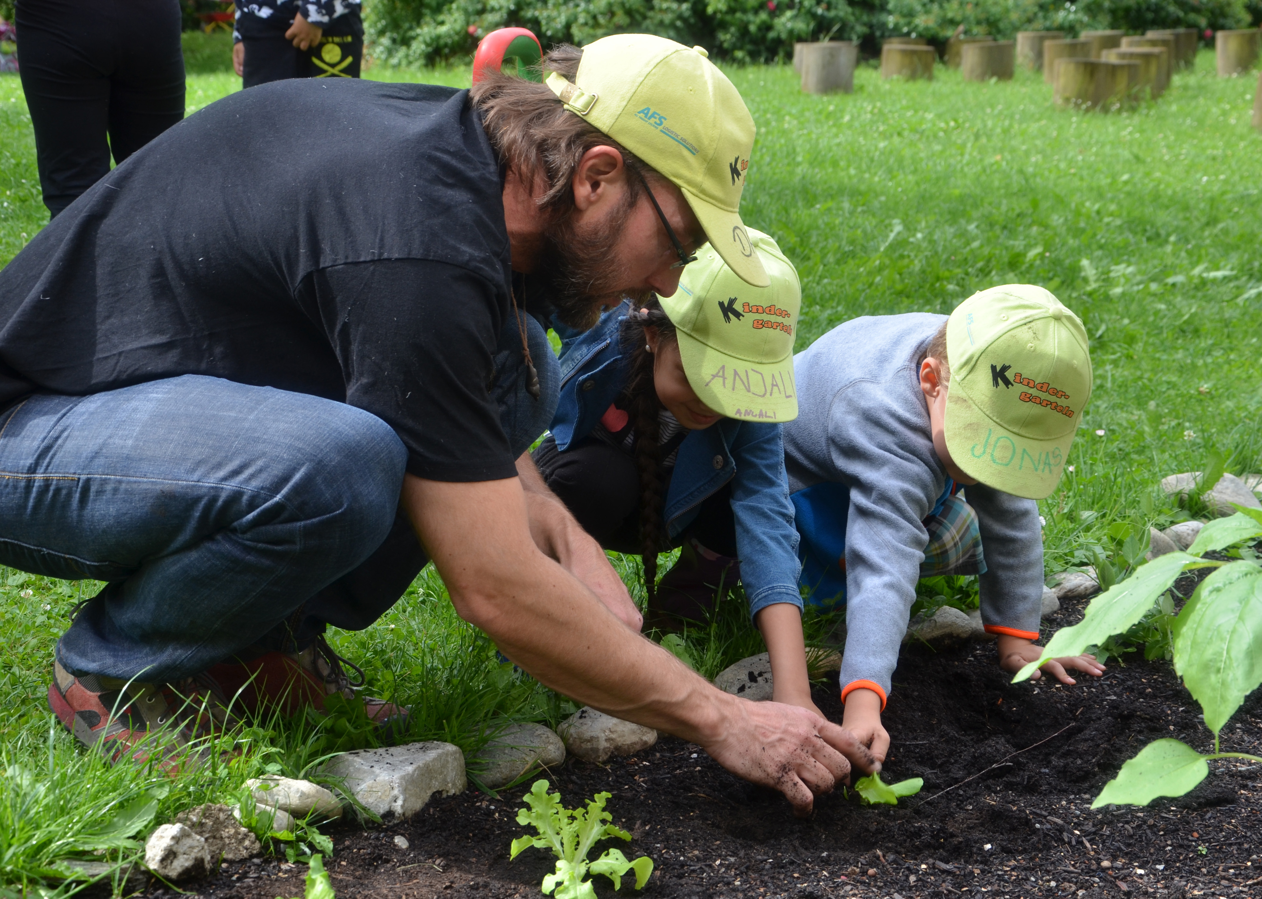 Danny Böttge (N.E.u.E. Verein) zeigt den Kindern wie man richtig Salat pflanzt.