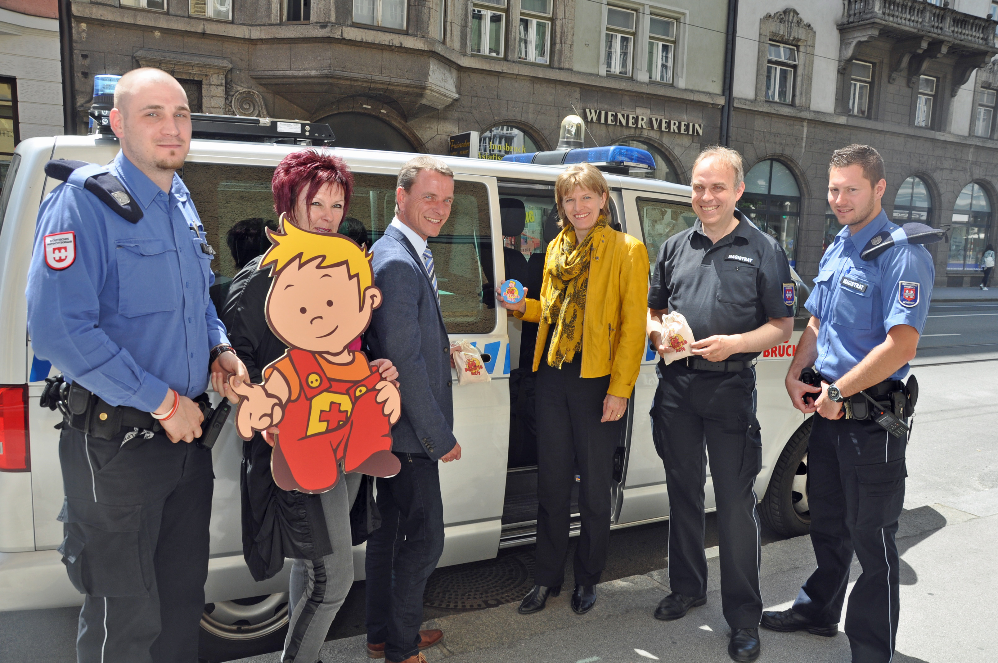„Peterle hilft“ mobil: MÜG-Mitarbeiter Johannes Rückauf, Referatsleiterin Uschi Klee (Frauen, Familie und SeniorInnen), Vizebürgermeister Christoph Kaufmann, Bürgermeisterin Christine Oppitz-Plörer, Amtsleiter Elmar Rizzoli (Allgemeine Sicherheit und Veranstaltungen) und MÜG-Mitarbeiter Marco Scheibenstock (v. l.) statteten das Einsatzfahrzeug der Mobilen Überwachungsgruppe mit einem „Peterle hilft“-Sticker aus.