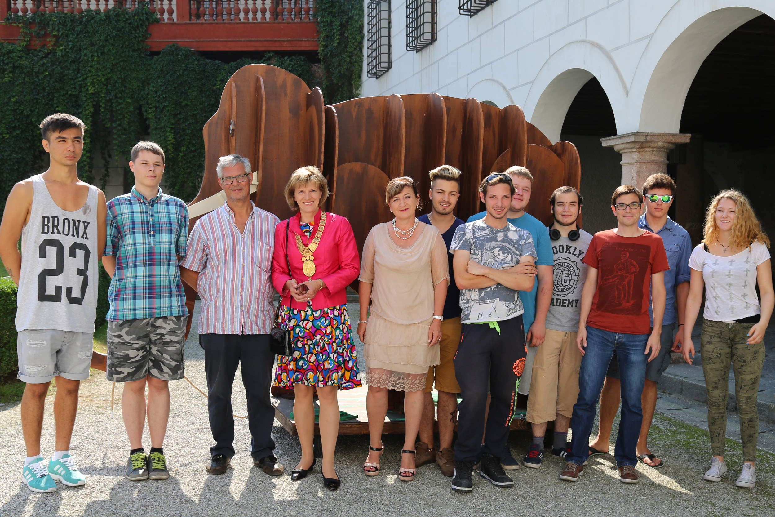 Bürgermeisterin Christine Oppitz-Plörer und Landesrätin Beat Palfrader (Bildmitte) mit den SchülerInnen der "LEA Produktionsschule" und ihrem Werkstättenleiter Klaus Ribitsch vor deren Holzkonstruktionen, die einen Elefanten und ein Nashorn darstellen und als Requisiten auf Schloss Ambras Innsbruck verwendet werden.