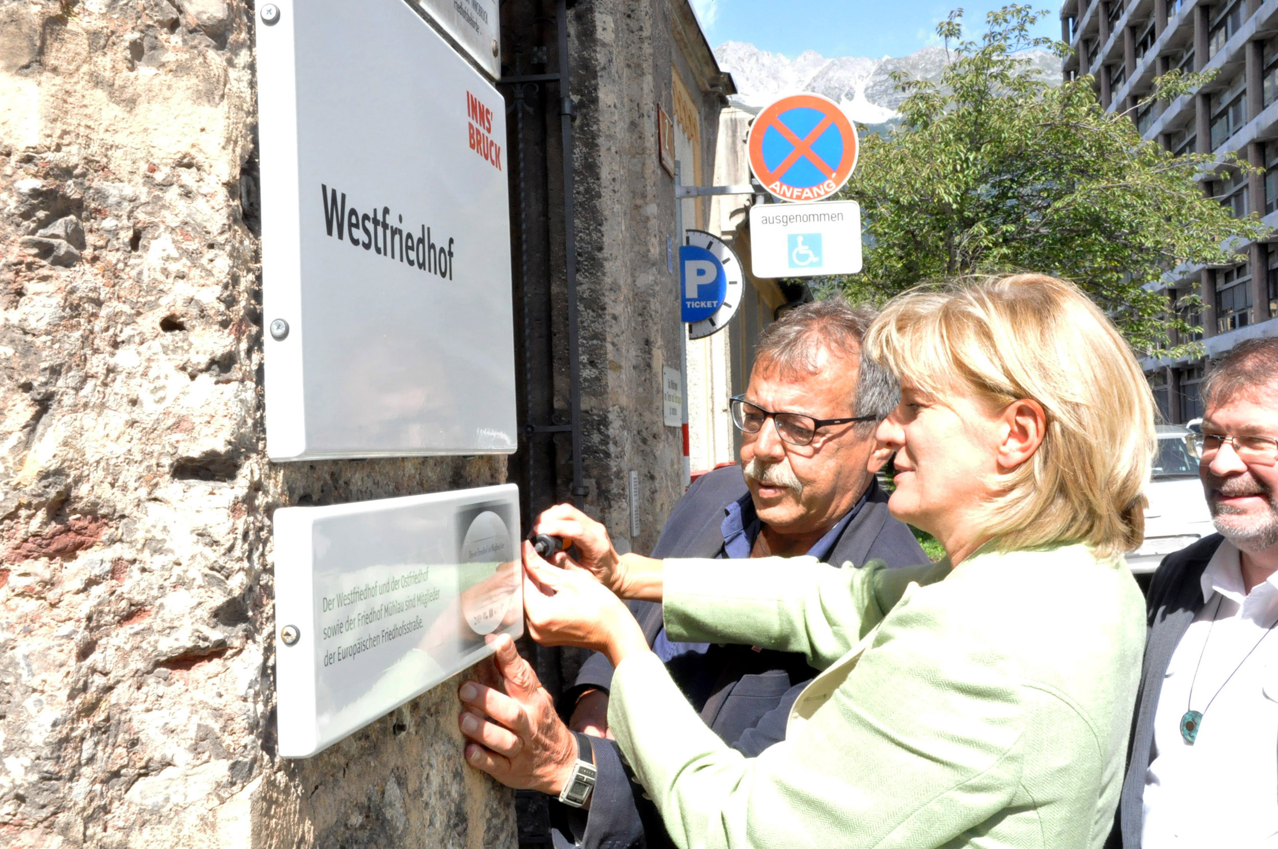 Bürgermeisterin Christine Oppitz-Plörer legte bei der Montage der neuen Tafel am Westfriedhof selbst Hand an. Stadtrat Gerhard Fritsch und Alexander Legniti (Referatsleiter Friedhöfe) zeigten sich über die Anbringung erfreut.