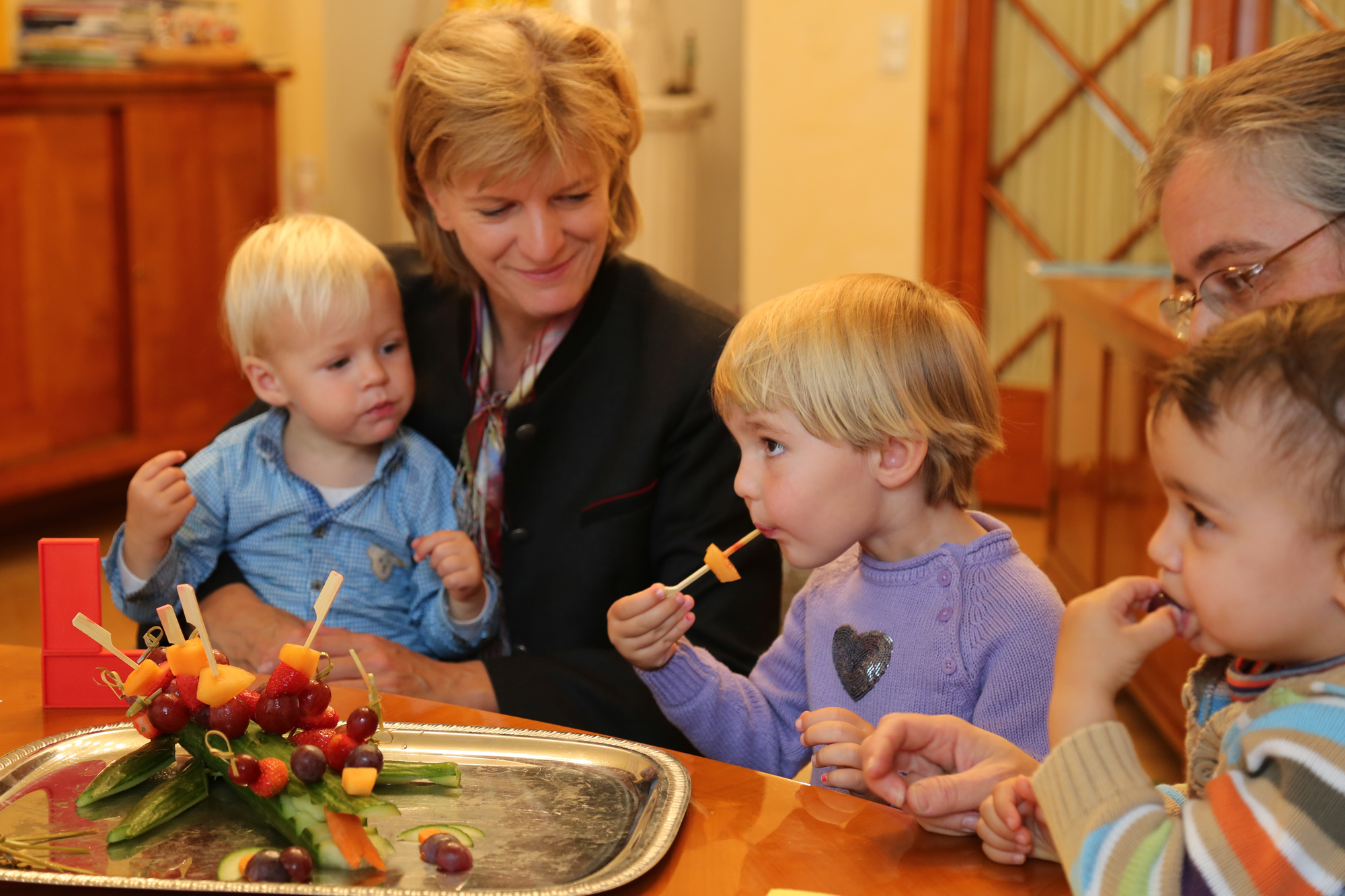 Bürgermeisterin Christine Oppitz-Plörer mit den Tageskindern Miro, Franziska und Raphael, denen die Gesunde Jause sichtlich gut schmeckt.
