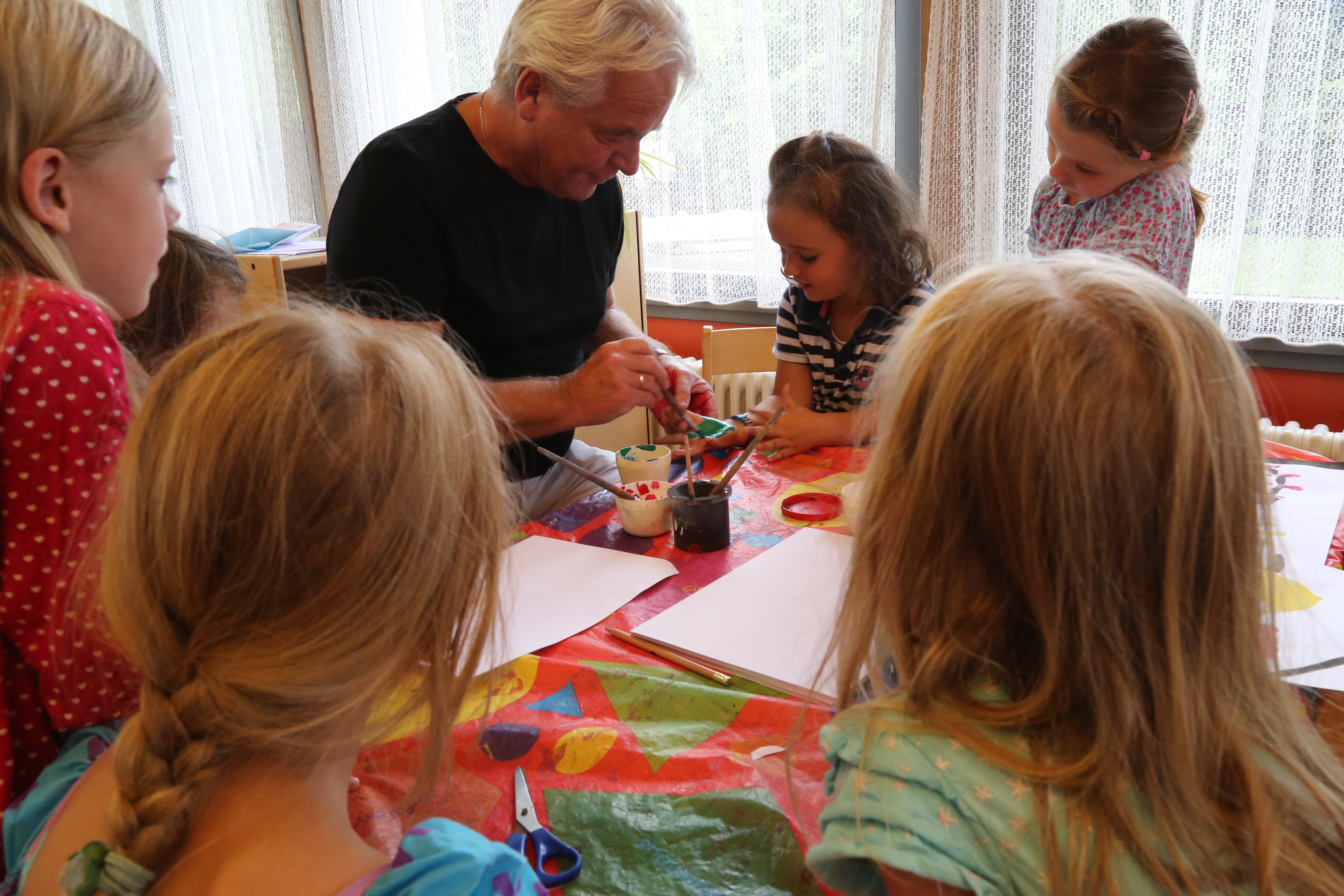 Stadtrat Ernst Pechlaner beim Malen mit den Kindern des Sommerkindergartens Peergründe.