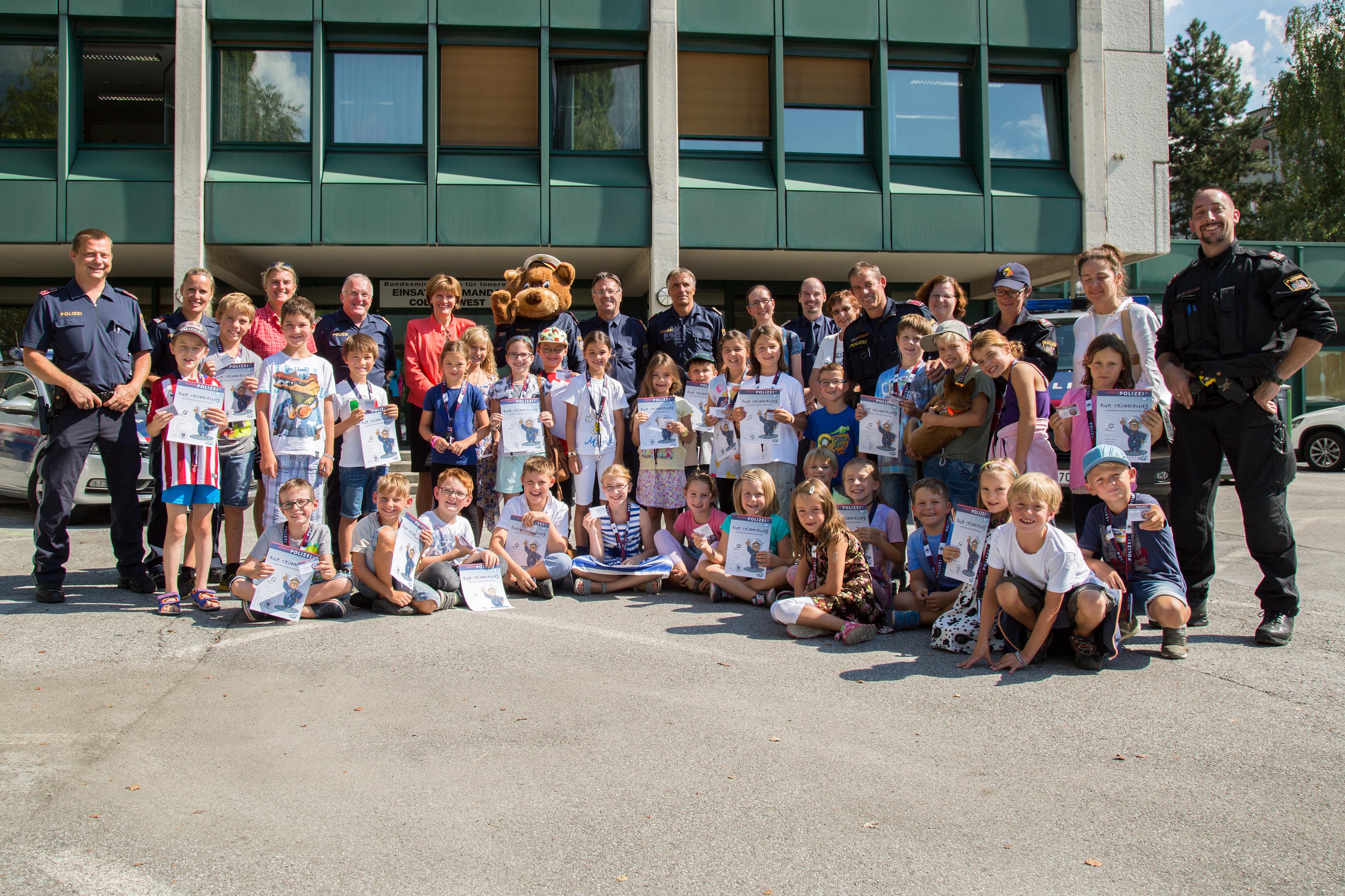 Die neuen Kinderpolizei-InspektorInnen nach der Diplomverleihung mit Bürgermeisterin Christine Oppitz-Plörer (hintere Reihe, 5.v.l.), Oberst Reinhard Moser (hintere Reihe, Mitte) und Referentin Birgit Ginter (hintere Reihe, 3.v.l.) vom Innsbrucker Ferienzug.