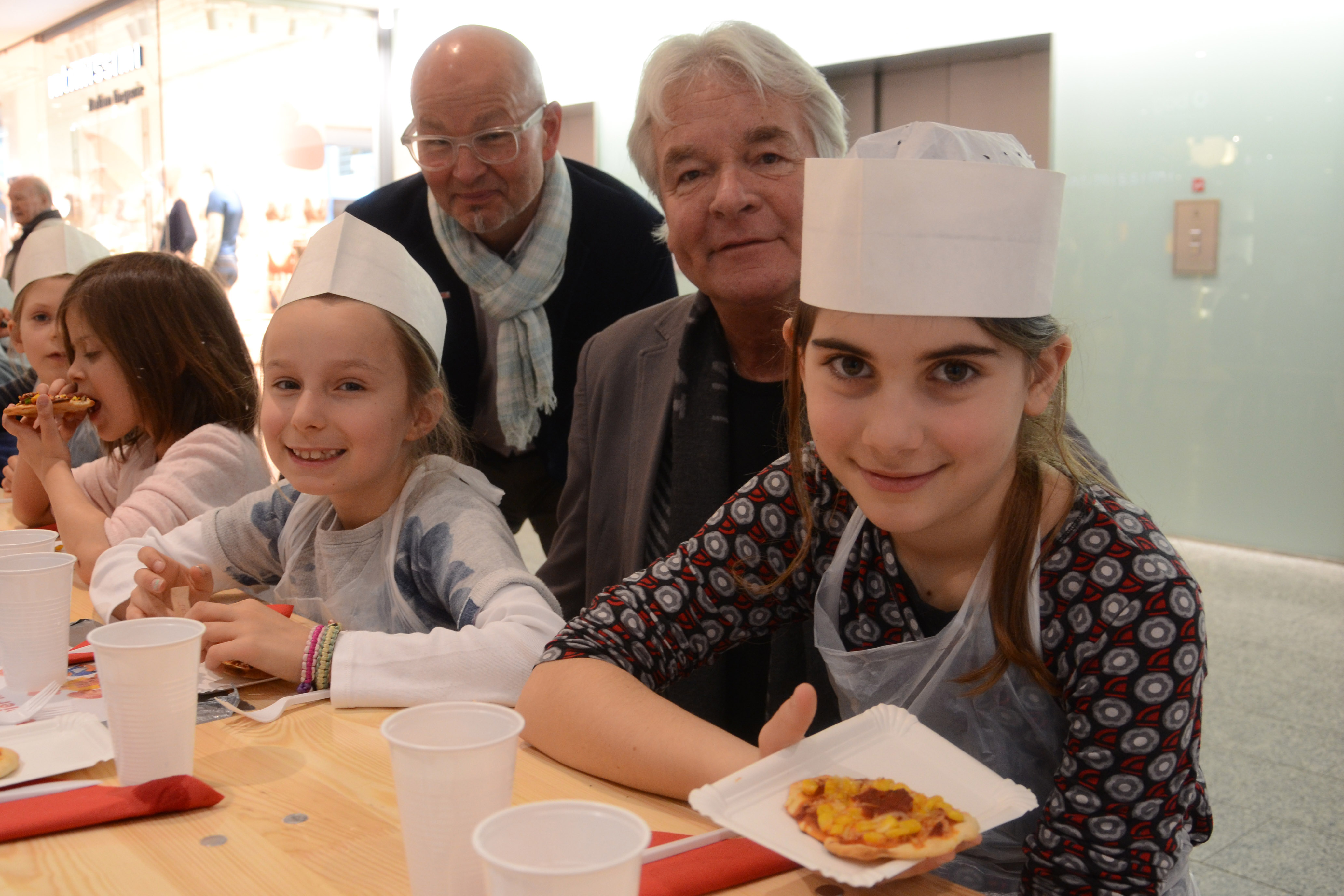 Stadtrat Ernst Pechlaner (hinten r.) und Schulamtsleiter Werner Leithmayer (hinten l.) schauten bei der Mitmachausstellung „Guten Appetit“ vorbei, die von der Stadt Innsbruck finanziell unterstützt wird, und erfuhren von den Kindern interessantes über gesunde Ernährung.