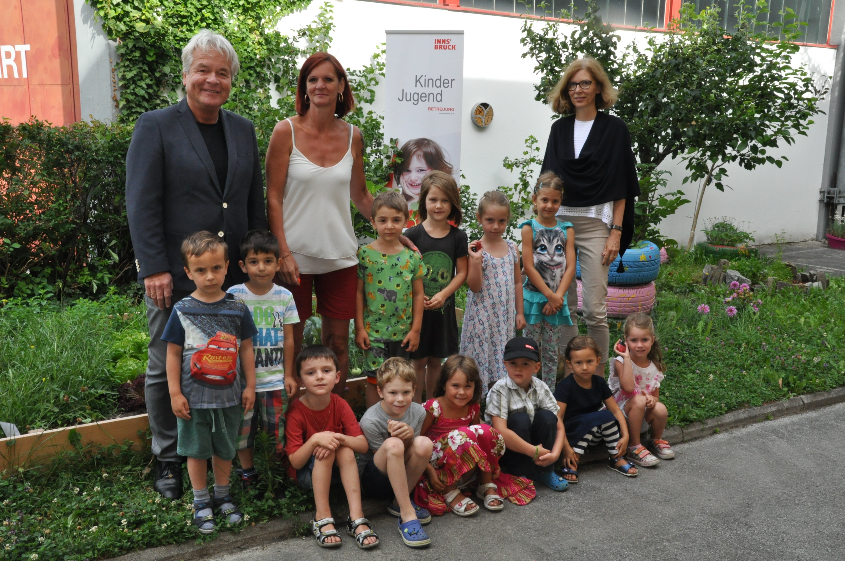 Die Kinder im Kindergarten Sieglanger mit grünem Daumen und (v.l.) Stadtrat Ernst Pechlaner, Kindergartenleiterin Edith Melojer und Martina Zabernig (Leiterin Amt für Kinder, Jugend und Generationen).