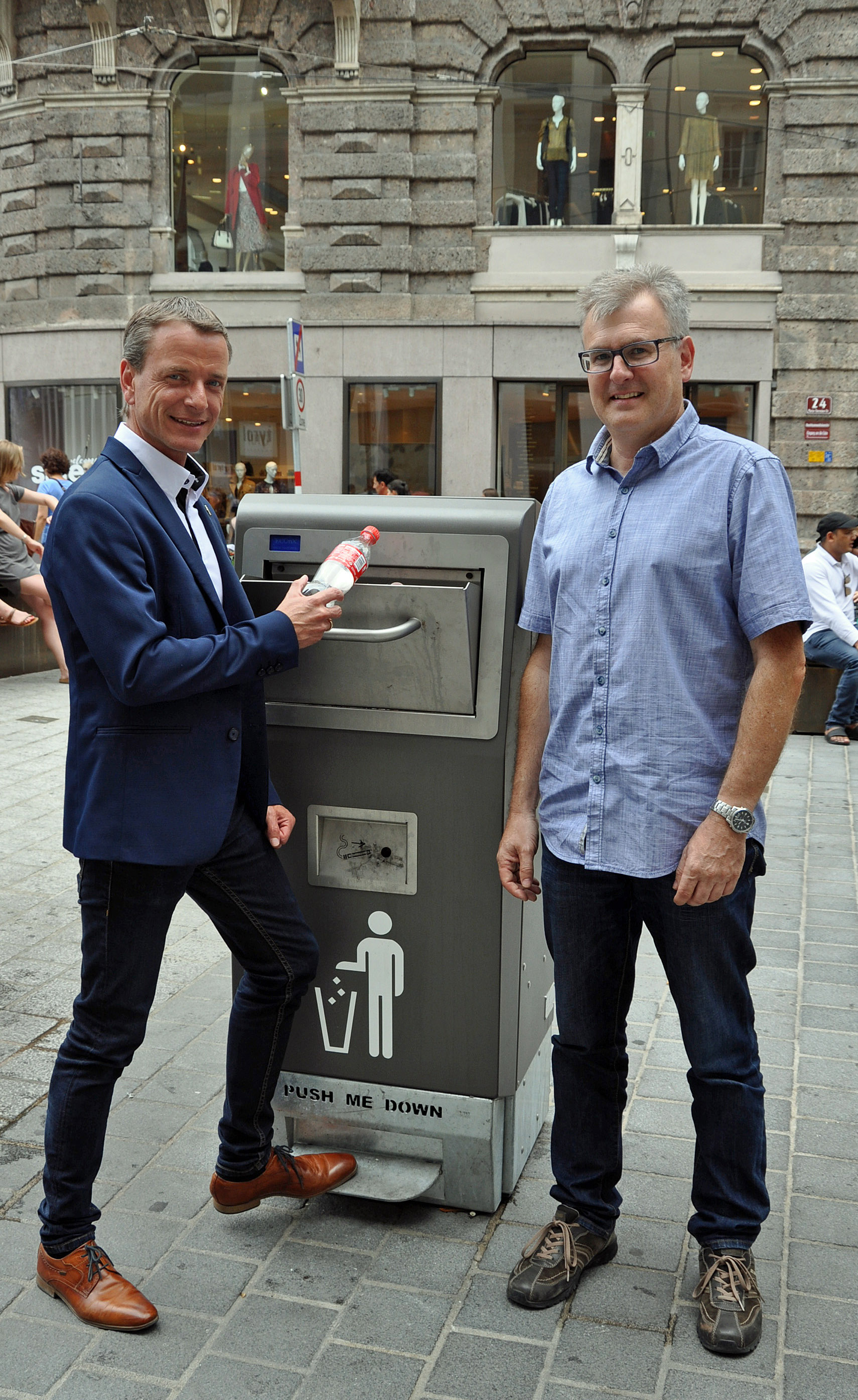 Vizebürgermeister Christoph Kaufmann und Josef Mühlmann, Vorstand des Amts für Straßenbetrieb, präsentieren gemeinsam die neuen, intelligenten Müllkübel in der Maria-Theresien-Straße.
