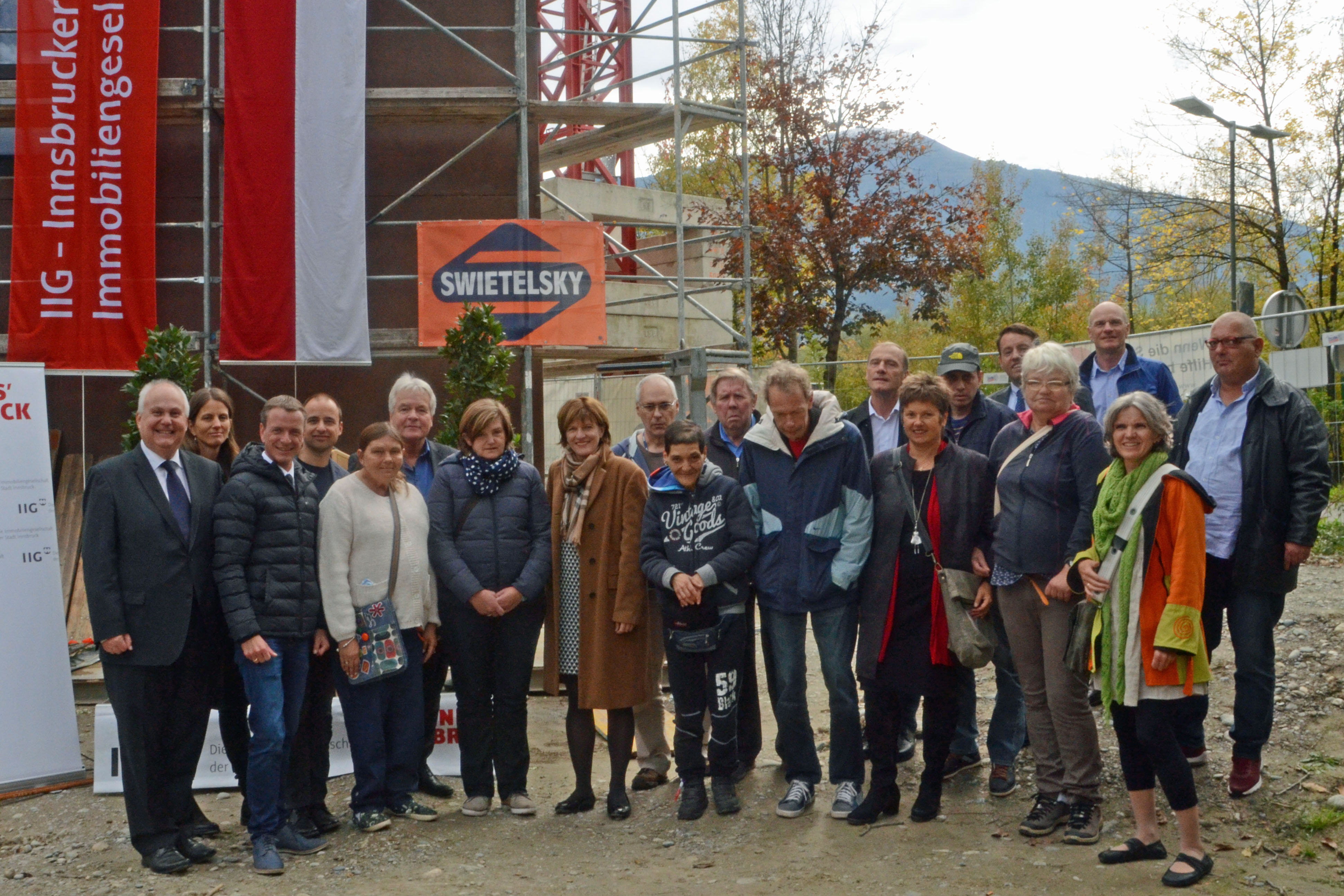 Bei der Firstfeier des Hauses für psychosoziale Begleitung und Wohnen im Olympischen Dorf: Wohnungsstadtrat Andreas Wanker, Architektin Julia Fügenschuh, Vizebürgermeister Christoph Kaufmann (v. l.), Stadtrat Ernst Pechlaner (6. v. l.), Bürgermeisterin Christine Oppitz-Plörer (8. v. l.), IIG-Geschäftsführer Franz Danler (5. v. r.) sowie Vertreter des Vereins Psychosozialer Pflegedienst Tirol und zukünftige BewohnerInnen.