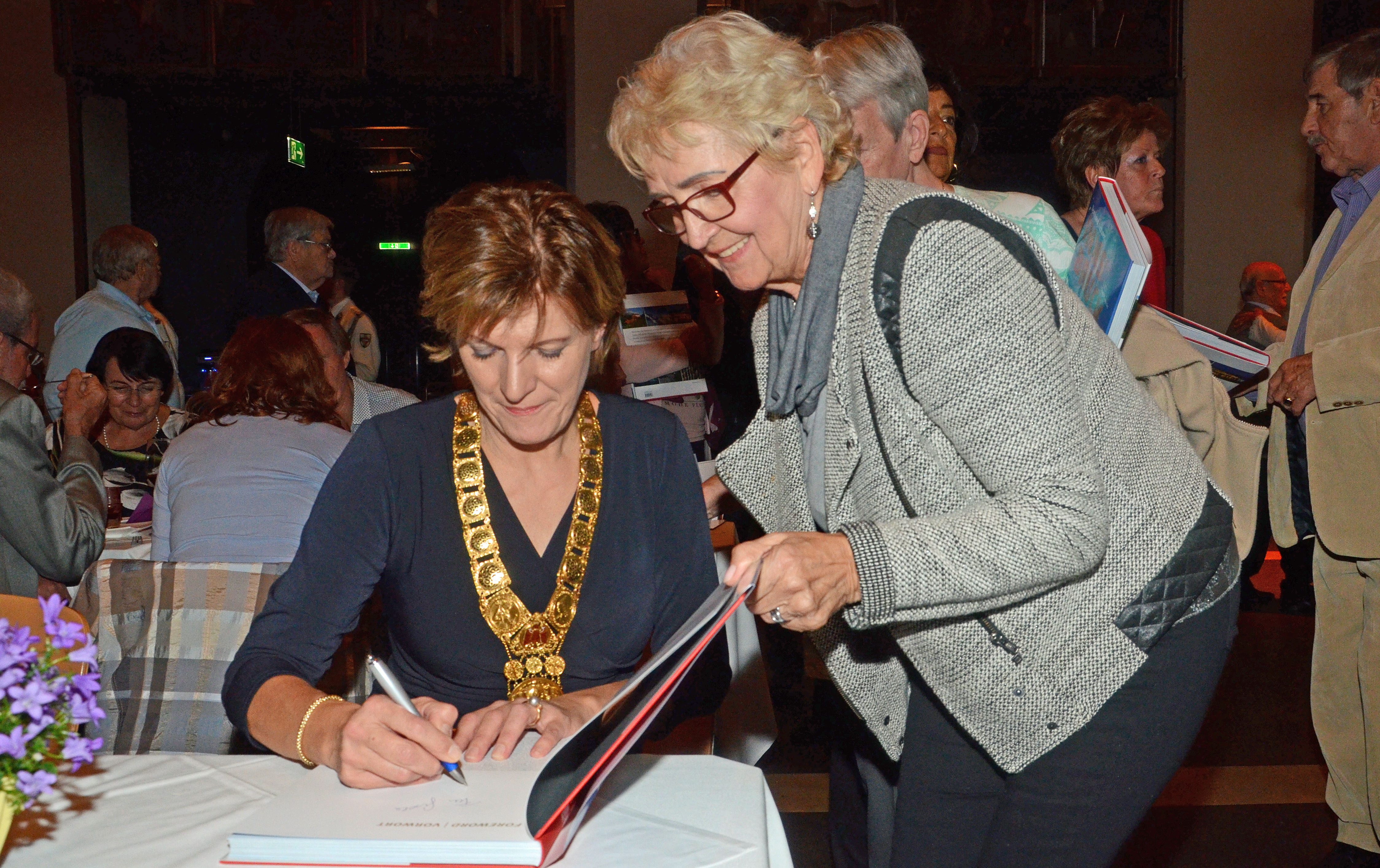 Für die Geburtstagskinder gab es ein „Innsbruck“-Buch als Geschenk. Viele Anwesende – unter ihnen Gisela Rott – ließen sich das Werk von Bürgermeisterin Christine Oppitz-Plörer signieren.